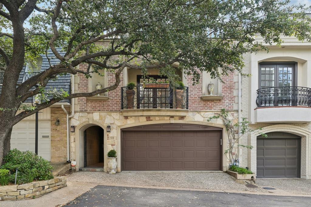 A private gate. A tree-lined drive sloping toward Turtle Creek. And behind it — one of only 25 townhomes in Christopher Place, a gated enclave so quiet most of Dallas doesn't know it exists.

This European-inspired residence delivers the drama the moment you walk in — soaring double-height ceilings in the main living area, multiple skylights pouring natural light through every level, and crystal chandeliers and wrought-iron railings that thread old-world elegance through a thoroughly modern renovation.

The remodeled kitchen features marble countertops, a patterned tile backsplash, a professional-grade gas range, and a built-in refrigerator with custom cabinetry panels. A walk-in pantry with its own countertop for small appliances keeps the workspace clean. The formal dining room offers wainscoting, glass-front cabinetry, and its own chandelier — sized for entertaining.

Upstairs, the primary suite occupies its own wing with hardwood floors, a generous sitting area, French doors to a private balcony, and a fully remodeled bath with freestanding soaking tub, dual marble vanities, and an oversized glass-enclosed shower. A second ensuite bedroom and an open loft overlooking the living room below complete the upper level.

Outside, a private flagstone courtyard is framed by stone walls, a carved fountain, and bamboo screening — an outdoor room that feels lifted from the Mediterranean. A wrought-iron balcony above connects the indoor and outdoor living.

Christopher Place sits along Turtle Creek Park, with an HOA-maintained section providing a private creekside retreat for residents. The Katy Trail is moments away, Highland Park borders the community to the north, and the best of Uptown and Oak Lawn are just beyond the gate.