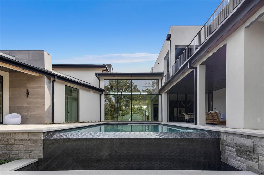 This stunning modern residence, built by Heritage Homes offers a harmonious blend of luxury and functionality. The expansive, open floorplan welcomes you with an abundance of natural light streaming through extensive window glass, creating a bright and airy atmosphere throughout. A sleek standing seam metal roof crowns the home, adding both durability and contemporary flair.

Step inside through the custom iron and wood front door to discover a grand entry featuring a striking floating staircase and a sophisticated wine display, setting the tone for the elegance within. The heart of the home boasts a spacious family room with a linear fireplace, seamlessly complemented by another linear fireplace in the expansive outdoor living area perfect for year-round entertaining. Large slider doors provide effortless access to the outdoors, enhancing the indoor-outdoor flow.

The gourmet kitchen is a chef’s dream, equipped with top-of-the-line Thermador appliances, custom cabinetry, and stunning stone countertops. Hand-selected decorative lighting adds a touch of artistry, while Emtek door hardware and 8 ft solid core interior doors elevate the home’s refined aesthetic. Tile flooring flows throughout, offering both beauty and practicality.

Retreat to the luxurious master suite, where the spa-inspired bathroom steals the show with an oversized shower, a freestanding tub, and impeccable finishes. The home’s thoughtful design extends to its open cell foam insulation for energy efficiency, glass and steel garage doors for a modern edge, and an oversized pool with a heated spa for ultimate relaxation.

Additional highlights include a versatile layout with generous proportions, perfect for both everyday living and grand gatherings. This is more than a home - it’s a masterpiece of style, comfort, and innovation.