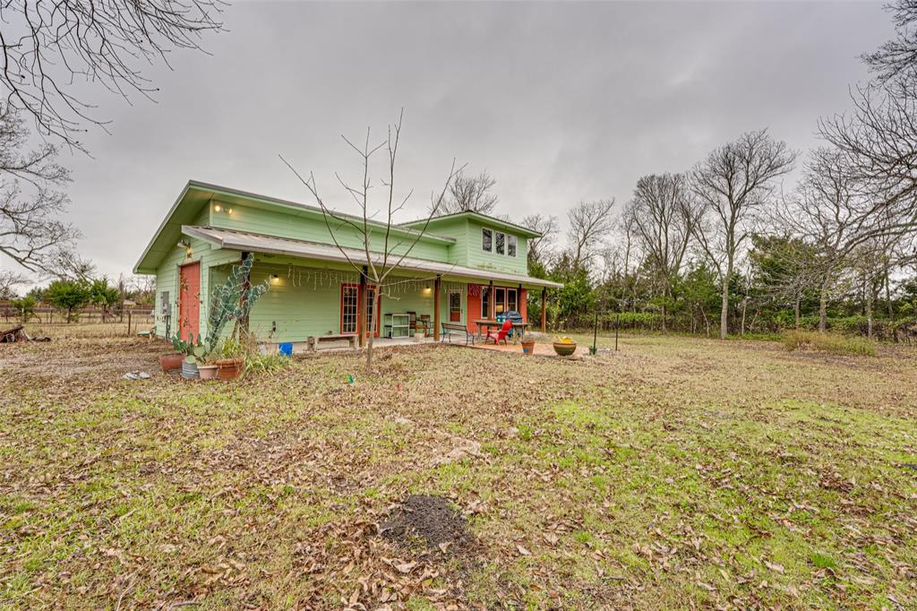 Perfect for home-based business, room to grow, live-work environment.  Rare 1.18-acre flag-shaped lot in the heart of Farmersville offering privacy, versatility and prime in-town convenience.  Water, electricity, and pressurized city sewer connection installed. Heavily treed with beautiful scenery, privacy, and an array of Texas indigenous flora, this unique property offers a large buildable area, mature trees, and two attached structures, including a 630 sq ft workshop-garage with an 8' door and a two-story accessory unit. The studio features approximately 396 sq ft on the main level with a kitchenette, shower, and ample space for a living and dining area, plus a spacious 350 sq ft loft above. Built in 2015 and connected to city services, the accessory unit is not permitted as a permanent dwelling and is intended for guest use, previously serving as a weekend retreat. A backup generator is included for the workshop and accessory unit building. City-approved 3-bedroom, 2-bath home plans are available for purchase or with acceptable offer, and a previous home site remains with slab and utilities in place.  A storage trailer will remain with the property. Ideal for builders, investors, or anyone seeking a private in-town homesite with room to grow and escape the hustle and bustle.
