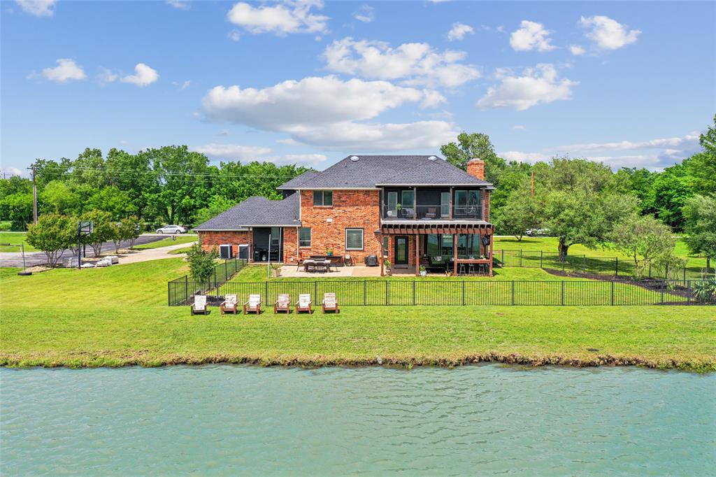 Discover a rare opportunity for luxury lakeside living just minutes from the Metroplex in the exclusive private Ski Haven near Justin, TX. Conveniently located within 15 minutes of Hwy 114 & I-35W, this unincorporated waterfront retreat offers peaceful lake living with easy access to DFW airport & Fort Worth in under 30 minutes. Situated on one of eleven private one-acre homesites surrounded by privately owned land, this custom two-story home offers exceptional privacy, breathtaking views, & a lifestyle centered around relaxation and recreation. Inside, the spacious floorplan features a large living & dining area with oversized windows overlooking the lake. The kitchen is beautifully appointed with custom cabinetry, granite countertops, tile finishes, and an oversized nearby laundry room. Upstairs, the luxurious primary suite includes its own fireplace, updated finishes, jetted tub, and a private balcony overlooking the lakes. Three additional generously sized bedrooms and well-appointed bathrooms provide ample space for family and guests. This meticulously maintained home includes wood flooring upstairs, updated lighting & hardware, four full bathrooms, two fireplaces & oversized garage. Ski Haven offers a truly unique lifestyle with exclusive access to a private lake. The property also offers the opportunity to add your own private dock, creating the ultimate lakefront experience. The 1.27% tax rate and HOA amenities provide excellent value. HOA includes water for the home and sprinkler system, 2 Trash dumpsters, 2 Ski Nautique boats with anytime use, 2 separate ski lakes, 1 for slalom, 1 for trick ski, jump & play such as jet skis & tubing, Second water well dedicated to keeping lakes at a constant level for year round enjoyment, 2 boat houses with lifts, lakes stocked with bass crappie & catfish. Also included is concrete pavilion with new metal roof replaced in 2025, recently repaved road and maintenance of common areas, systems, boats and buildings.