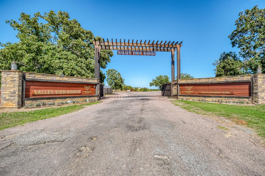 Not only is Valley View Ranch an income-producing equine property, but its commercial opportunities are endless thanks to its prime location in the heart of North Texas Horse Country. This full turnkey facility is designed for serious equestrian operations, complete with a 100x125 covered arena featuring holding pens, stalls, hot walker, wash rack, 2 offices, and more—all under roof. The 115x125 outdoor arena offers a viewing stand, holding pens, and roping boxes, making it ideal for events and training.

Across the property you’ll find 60 custom oversized stalls spread between 3 barns, each equipped with tack rooms, feed and storage areas, and automatic waters—all positioned conveniently near the arenas.

The main residence spares no expense in its finish out, boasting a large wraparound porch perfect for entertaining or relaxing while overlooking scenic ranch views. An additional home has been customized with an oversized living space, expanded bedrooms, wraparound porch, and an outdoor entertainment setup featuring a sand volleyball court and above-ground pool.

Supporting operations are 3 help homes, multiple holding pens, turnouts with shelters, and a thoughtfully engineered French drain system to distribute rainwater efficiently.

With its combination of operational excellence, residential comfort, and unmatched commercial potential, Valley View Ranch is truly a must-see property.