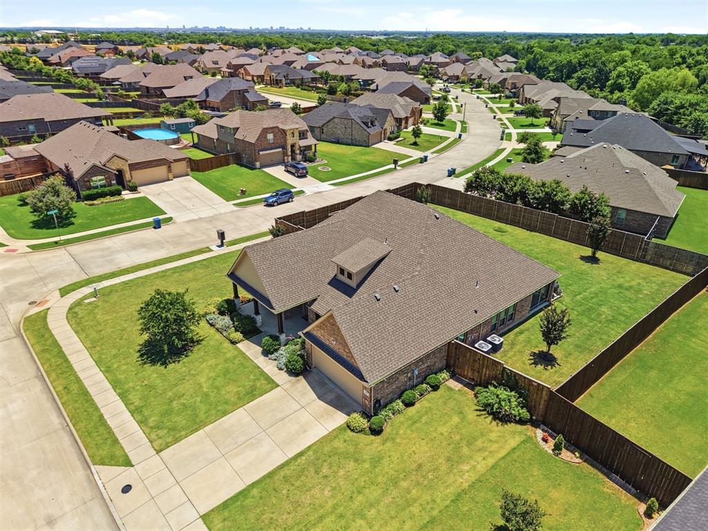 Nestled on a generous .388-acre corner lot within the prestigious Woodbridge Estates, this impeccably maintained 1.5-story home features a Texas sized backyard ready for entertaining or a future custom pool. An inviting covered front porch welcomes you into a warm, open-concept interior adorned with hardwood floors, a private study with French doors, and a formal dining area perfect for hosting guests or everyday family dinners. The chef’s kitchen serves as the home's centerpiece, boasting a large granite island, stainless steel appliances, upgraded venting, and a walk-in pantry, all flowing seamlessly into a sunny breakfast nook and a comfortable family room anchored by a cozy fireplace. The main-level primary suite provides a peaceful retreat with dual sinks, a large soaking tub, separate shower, and an oversized walk-in closet. Upstairs, a second living area that can serve as a game room if preferred and an additional flex space offers the perfect space for a craft area or a quiet reading nook. There is also a half bath upstairs for convenience. Enjoy the outdoors year-round from the comfort of the spacious window enclosed porch. Conveniently located just minutes from Lake Lewisville, shopping, dining, and major highways, this property offers unmatched space and flexibility in a prime location.