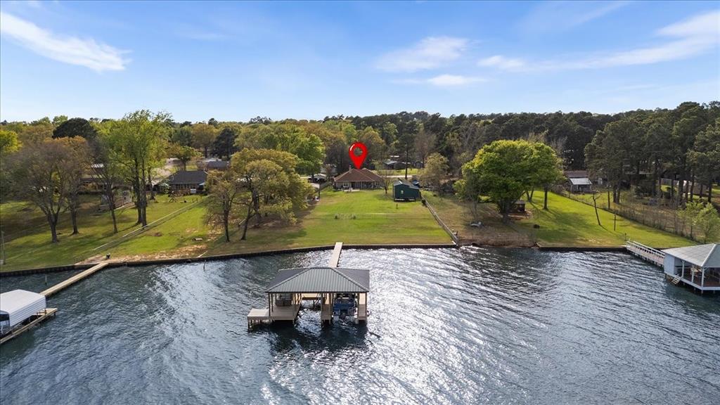 Welcome to your exquisite waterfront oasis on Lake Palestine, where stunning open water sunrise views set the stage for a life of luxury and leisure. Set on nearly 2 acres of pristine land, this immaculate four-bedroom, two-bathroom home features a thoughtfully designed split floor plan, ensuring privacy and comfort for family and guests alike.

Indulge in the elegant culinary experience provided by the stylish kitchen, complete with a gourmet gas stove, while the expansive covered back patio and beautifully manicured backyard offer the perfect backdrop for entertaining or relaxing in tranquility. With both the two-car garage and additional two-car carport showcasing new epoxy flooring, this property meets all your storage needs, including a massive 25 x 35 enclosed shop and workshop and a dedicated covered RV pad.

Experience the peace of mind with a Generac Generator, insuring uninterrupted power for your comforts. Enjoy 162' of captivating shoreline, enhanced by a brand-new retaining wall and a state-of-the-art two-stall boathouse, ideal for the boating enthusiast. This gem not only promises a luxurious lifestyle but also presents a prime investment opportunity as a highly sought-after Airbnb or VRBO destination. Experience the ultimate in waterfront living and make this enchanting retreat your own today!