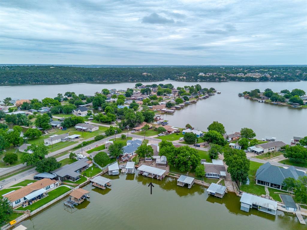 Experience the quiet luxury of waterfront living  on this rare lakefront retreat offering expansive outdoor living, exceptional dock infrastructure, and a lifestyle defined by peace, recreation, and unforgettable sunsets on the water. Perfectly positioned along the lake, this thoughtfully expanded residence—originally a manufactured home enhanced with multiple additions—has been transformed into a spacious and functional lake retreat designed to embrace indoor-outdoor living. A sun-filled sunroom invites natural light and serene water views, creating a seamless connection to the surrounding landscape. The true centerpiece of the property is the impressive covered wraparound metal dock, offering an extraordinary waterfront experience. Spanning approximately 52 feet by 30 feet, the dock is equipped for elevated lake living with two boat lifts, a double jet ski lift, and a single jet ski lift. Additional features include a dedicated fishing area, bait house-storage, and a bait system, all supported by dual remote lift controls for effortless access to the water. Designed for both relaxation and entertainment, the outdoor setting continues with a 12x24 workshop, additional storage structure with a covered wraparound deck, tool shed, and double carport. A stone walkway gracefully connects the home to outdoor living spaces, while a thoughtfully constructed retaining wall creates an inviting, elevated seating area overlooking the water. The natural rock shoreline presents additional opportunity for enhancement, with potential for custom plant ledges or expanded walkways that further elevate the waterfront experience and personalize the landscape. Whether envisioned as a private lake escape, a recreational retreat, or a high-potential short-term rental investment, this property offers unmatched versatility in a serene waterfront setting. The possibility of including a  Deck Boat further enhances its appeal for the ultimate lake lifestyle experience.