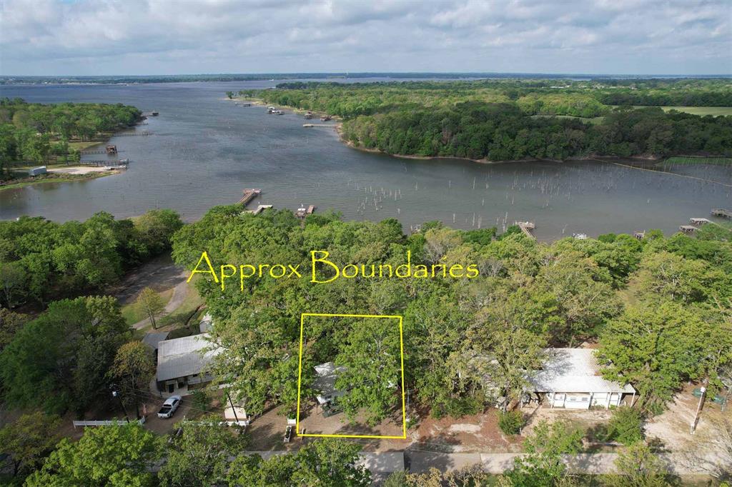 Lake Fork Waterfront Retreat with Stunning Sunset Views! Unwind and let the stress melt away from your expansive covered deck overlooking breathtaking sunsets on Lake Fork. This unique waterfront property offers the perfect blend of comfort, convenience, and relaxed lake living.  The property features a tastefully remodeled 37’ 2007 Challenger fifth wheel with four slide-outs, thoughtfully equipped with everything you need for extended stays or full-time living. Enjoy a spacious layout that comfortably sleeps four, along with a flat-screen TV, electric fireplace, microwave, and full-size refrigerator—all included and furnished for your convenience.  A bonus is the remodeled 1997 34’ Crown fifth wheel, ideal for hosting guests or extra sleeping space. It has been upgraded with a stacked washer and dryer, so you can enjoy the ease of on-site laundry without sacrificing space in the main unit.  Both RVs are protected under an oversized metal cover, connected by a large, covered deck perfect for entertaining or simply soaking in the lake views.  Situated on two waterfront lots shaded by towering trees, the property also includes two storage buildings and a gravel drive with ample parking space for boats and vehicles.  Located within one of Lake Fork’s most desirable gated RV communities, residents enjoy access to a swimming pool, pavilion, playground, boat ramp, and fishing pier—everything you need to make the most of lake life. Full list of recent updates available.