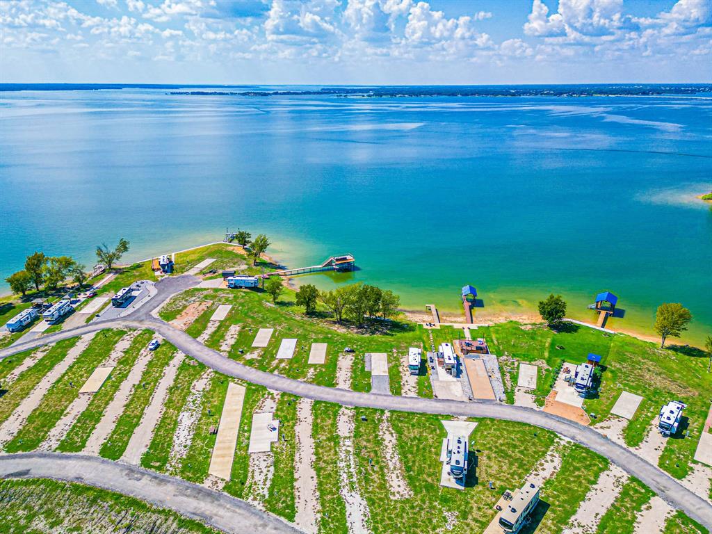 This fantastic lakefront property is eagerly anticipating your arrival to experience the upscale RV and tiny home resort on the beautiful Richland Chambers Lake. This lot offers a concrete pad already in place for you to bring your RV. Take in the spectacular views of the open water, enjoy both sunrises and sunsets with Richland Chamber Lake surrounding you on three sides. The community offers a clubhouse with many resort style amenities from a pool, laundry room, outside grill area, playground area, dog park, pier, fire pits with seating area to enjoy the sunsets, and it just goes on! Lake life is calling!
