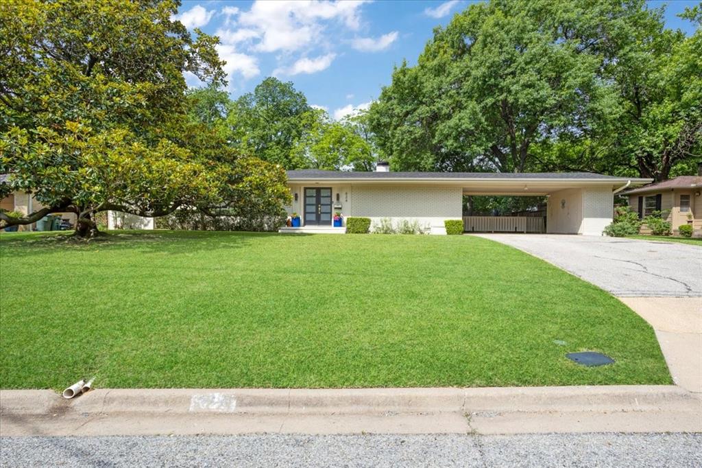 Welcome to 624 Westwood Drive! This stunning mid-century modern home in the heart of west Sherman has been tastefully updated and impeccably-maintained. Designed by well-renowned architect Donald Mayes, this home is truly one-of-a-kind, and MUST be seen in person to truly appreciate! Step inside to bright, open living areas with large windows and natural sunlight - all of which accommodate multiple spaces to relax or entertain. Dining area adjacent to kitchen boasts floor-to-ceiling window looking out to the backyard. Kitchen includes stainless steel appliances with a plethora of built-in cabinets and updated countertops. Living areas include formal living room, cozy den with wood-burning brick fireplace, and solarium room with skylight and wide windows overlooking the backyard. Original home features include herringbone brick floors in solarium and kitchen, wood paneling, crown molding, wood shutters, and oversized entryways. Each bedroom has ample closet space, and third bedroom boasts wide built-in desk that could easily double as an office. Primary bedroom features ensuite bathroom with double vanities, built-in shelving & cabinets, and spacious walk-in shower. Step out to the private, fenced backyard and enjoy the outdoors while relaxing on the oversized brick courtyard patio. Attached carport allows for plenty of parking space, and includes an electric vehicle charger plus additional storage room. HVAC system was replaced in June 2024, as well as replaced ductwork under the house. Tankless water heater installed in June 2024. Roof replaced in May 2026. This kind of home doesn't come on the market often, so don't miss your chance to see this beautiful home in person. Call your favorite Realtor and schedule your viewing today!