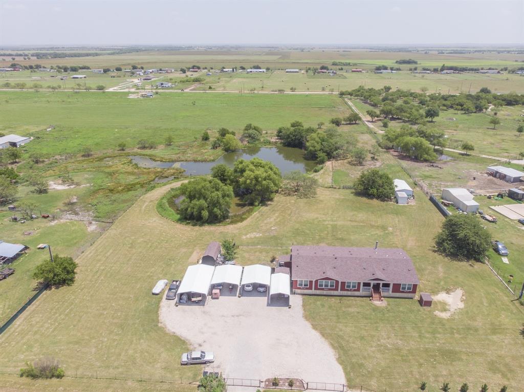 Looking for room to spread out & live the country life while close to conveniences? This one has it! There is a welcoming feel to the home & property, giving you space & functionality. You get 2 lots for 4 acres that is completely fenced with no climb fencing. The second lot already has it's own electric running to the pole. NO city restrictions or taxes & NO HOA. Enter the property at either of the 2 gated driveways & park under any of the 7 vehicle covered parking areas. Work on projects in the convenient workshop with electric that has covered parking to work. Step inside this impressive & comfortable home that has an open concept design. You get privacy with the split bedroom design & all on one level. Sit back & take in a movie in the large media room. There are custom features throughout with crown molding, custom ceiling fans, lighting & more. Be sure to ask to look at the extensive list of improvements made to the home & property. This comfortable & spacious modular home should not be mistaken for a mobile home as it is Not & is treated as site built home which you will see & feel once inside. Have you been wanting room & a place for keeping horses or just space to breath? This one delivers on many levels. There is an insulated barn with a loafing area that has water & electric, 3 separate gated pastures & 2 ponds with the largest not having dried that has fish, turtles & wild life that visit. If that is not enough than just sit back, relax to let your cares slip away looking out at your back yard with mature trees throughout. If you need easy access for commuting convenience, you can take the newly opened Dallas Parkway only a couple of miles down the road. This one truly has so much to offer that you have to see it to appreciate it. Grab the opportunity to own 4 acres & an wonderful home for less than others with features this one has in the rapidly growing Pilot Point area. Come see how special this one is to make it yours.