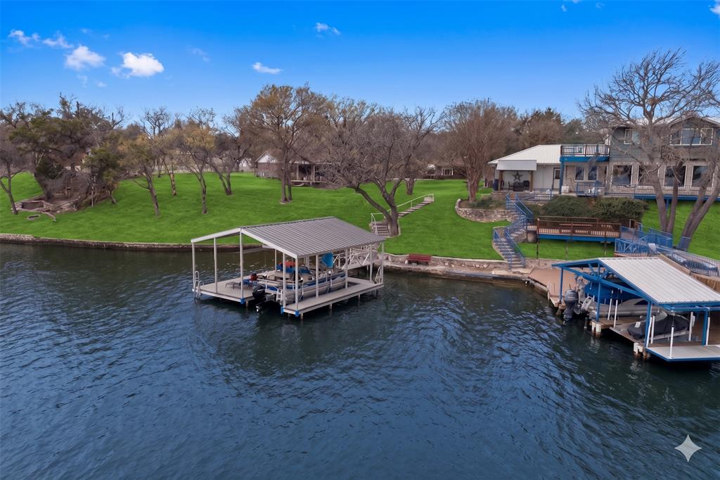 This remarkable lakefront retreat in Granbury, Texas, presents an exceptional opportunity that harmoniously combines luxury, comfort, and investment potential. Boasting four spacious bedrooms and three well-appointed bathrooms, the home is meticulously designed to include an expansive living area for entertaining or relaxation. The kitchen is perfectly suited for entertaining, as well as everyday living, making it a central hub for family and friends. The thoughtful layout fosters a welcoming atmosphere, ideal for hosting gatherings while preserving a serene, private retreat ambiance. Whether you are entertaining loved ones or enjoying a peaceful weekend getaway, this home truly embodies the essence of a waterfront lifestyle.

The outdoor living space is equally impressive, enjoy breathtaking views of the lake while seamlessly merging indoor comfort with the natural beauty of the outdoors. Features include a sizable dock with a boat slip and ample room for fishing and other activities, designed for year-round enjoyment. The property sits on an oversized lot strategically positioned to capture stunning lake vistas, providing an abundance of space for enjoying the joys of lakefront living.

Situated in one of the most desirable lakefront communities near the DFW area, Granbury is thriving with strong tourism, family getaways, and weekend visitors. Just minutes from the historic downtown Granbury, residents and guests benefit from convenient access to dining, shopping, entertainment, and community events.

In addition to its lifestyle appeal, this property possesses significant Airbnb potential. Whether you envision this as a primary residence, vacation home, or investment property, this retreat offers a sanctuary of tranquility and peaceful surroundings.
This is a rare opportunity to acquire a lakefront property that delivers lifestyle value, income potential, and proximity to the vibrant DFW area all within one of the most sought-after waterfront communities.