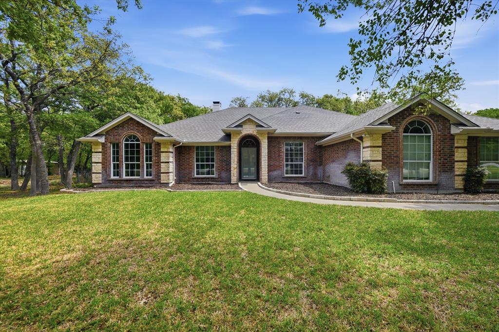 Located in the popular Turtle Creek Ranch community just outside the Fort Worth city limits, this 4-bedroom, 2.5-bath home offers the space, flexibility, and relaxed lifestyle buyers are searching for.  Step inside to a welcoming foyer that opens to a formal dining area and spacious living room with beautiful wood floors, all flowing together in an inviting open floorplan ideal for everyday living and entertaining. The kitchen is designed for gathering, featuring a large island, breakfast bar, abundant counter space, and a refrigerator that stays, making it move-in ready from day one.  The split-bedroom layout offers privacy for the generously sized primary suite, complete with an ensuite bath featuring dual vanities, a soaking tub, separate shower, and a walk-in closet. On the opposite side of the home, three additional bedrooms, each nicely sized that share a full bath, creating a comfortable setup for family or guests. A versatile bonus room provides extra flexibility and is perfect for a game room, office, or entertainment space.  Outside is where this property truly shines. Enjoy relaxing evenings on the covered patio overlooking the fully fenced backyard, all set on a beautiful 1+ acre lot with mature trees that provide shade and privacy. The home also features a 2-car garage and an impressive 16x24 two-story workshop, offering approximately 720 square feet of space with storage below and a finished upstairs game or music room. A constructed aviary adds a unique touch for hobbyists or animal lovers.  With no HOA and a terrific location offering easy access to Fort Worth, Lake Worth, and Azle, this property blends peaceful country living with convenient city access.  Come see the space, versatility, and lifestyle this Turtle Creek Ranch property has to offer.  Schedule your private showing today.
