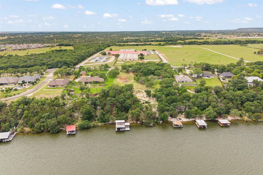 Build your dream waterfront retreat on this exceptional 2+ acre property overlooking beautiful Lake Granbury. Featuring beautiful oak trees, cleared, and ready for construction. This premier homesite offers breathtaking panoramic lake views and the perfect canvas for a luxury lakefront estate.

Designed for both recreation and entertaining, the property features a brand-new 46x32 boathouse complete with two boat lifts, two jet ski lifts, and an expansive upper-level helipad, creating a truly one-of-a-kind waterfront experience. Adding to the convenience and functionality, the property is equipped with a tram power system, making access to the lake and dock effortless. A well-designed switchback road seamlessly connects the upper and lower portions of the property, providing easy access to Lake Granbury. 

Whether you’re envisioning a weekend getaway or a full-time luxury lakeside residence, this rare property combines privacy, accessibility, and unmatched amenities in an incredible waterfront setting. Enjoy boating, fishing, and unforgettable Texas sunsets from your future dream home on Lake Granbury.