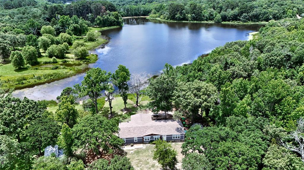 Affordable Lakefront Living! Enjoy peaceful waterfront living on beautiful Lock Lake, a private spring-fed lake of approximately 14 acres shared by only a handful of owners. Built in 2022, this spacious 4-bedroom, 2-bath home offers approximately 2,800 square feet (per seller) and is ideal as a relaxing getaway or full-time residence. The open-concept floor plan features a split-bedroom layout, a spacious kitchen with stainless steel appliances, a center island, a butler’s pantry, and an oversized walk-in pantry. The kitchen flows seamlessly into the large living area and separate dining room, creating an inviting space for entertaining and everyday living. The generous primary suite includes a luxurious ensuite bath designed for comfort and relaxation. A large sunroom provides the perfect place to enjoy lake views, gather with family and friends, or unwind after a day on the water.