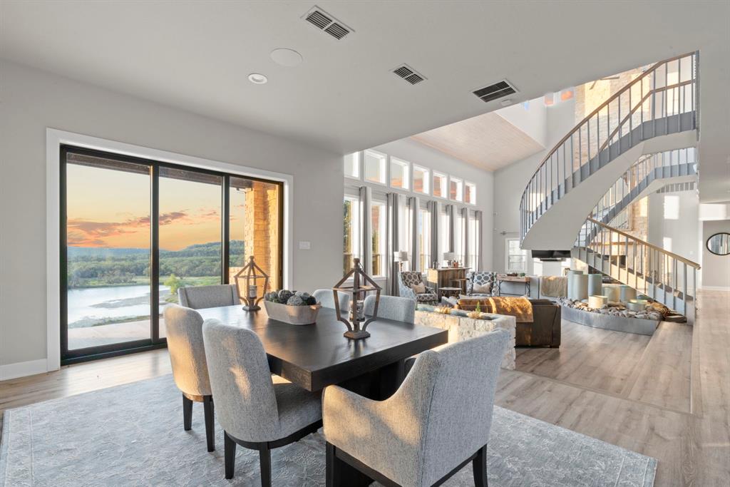 Tucked into the rolling hills west of Fort Worth, where the horizon stretches wide and the silence is only broken by birdsongs and the breeze, awaits a property unlike anything else on the market. Inspired by Hill Country elegance and built for a lifetime, this steel-framed, Austin stone estate sits proudly on over 40 secluded acres—overlooking its own private, fully stocked 5-acre lake.
Arriving through a gated entrance and winding drive, the first glimpse of this architectural gem will take your breath away. Set back more than 1,500 feet from the road, the home sits elevated and surrounded by trees, offering absolute privacy and promising forever views of the Palo Pinto Mountains and big Texas sunsets.
Step onto the wraparound porch and into a life of serenity. Inside, soaring ceilings and expansive windows frame breathtaking views in every direction. The open-concept great room centers around a grand freestanding double staircase—an artistic focal point. Beneath it, a locally crafted metal water feature dazzles with an illuminated nighttime display, dancing light across the space and creating a calming ambiance.
The kitchen is built for gathering, with upscale appliances including a commercial-grade refrigerator and freezer, a wine cooler, trash compactor, dishwasher, and a charming serving window perfect for hosting. The main-level primary suite is a luxurious retreat, complete with fireplace, spa-style bath, and private patio access.
Above the detached garage, your guests will enjoy their own fully equipped studio apartment with a private balcony and panoramic views.
Fully fenced with cattle guards, ag-exempt, and unrestricted—ideal for agricultural, recreational, or equestrian pursuits. Whether you're fishing at dusk, sipping coffee on the porch at sunrise, or simply soaking in the stillness of the land, this home offers a lifestyle rooted in beauty, peace, and permanence.