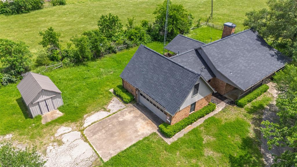 Discover your own piece of country heaven! Situated on 11.4 fenced acres, this inviting 1980 brick ranch-style home combines quiet rural living with everyday modern convenience. Offering approximately 1,763 sq ft of cared-for living space, this 3-bedroom, 2-bath home showcases a functional split-bedroom layout designed for comfort and privacy. Step inside to find a spacious living room featuring a warm gas log fireplace, perfect for cozy nights at home. The kitchen includes plenty of cabinet space and a breakfast bar, opening smoothly into the dining area — ideal for daily living or hosting family and friends. Take in peaceful scenery from every window, surrounded by mature trees, while a circular driveway creates a welcoming entrance to the property. The primary suite features dual vanities, a jetted soaking tub, separate shower, and an attached office or bonus room — ideal for remote work or relaxing in your private getaway. A roomy utility area adds convenience, while the attached 2-car garage offers additional storage and covered parking. Outdoors, you’ll find endless potential. A barn is already in place, making the property perfect for horses, cattle, or other animals. Whether you dream of creating a hobby farm, planting a garden, or simply enjoying wide-open land, this property is ready to fit your lifestyle. Experience true country living — peaceful, spacious, and filled with possibilities, while still being conveniently located near town amenities. Don’t miss the opportunity to own this stunning Texas countryside retreat. Schedule your showing today and see everything this unique ranch property has to offer!