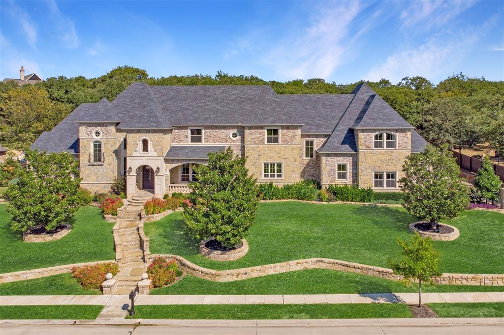 Tucked inside the prestigious Manors at Waterford, this award-winning custom estate offers a rare blend of timeless design, exceptional construction, and true resort-style living. Spanning 6,353 sqft on pier-and-beam foundation, this immaculate residence is designed for those who expect both everyday comfort and unforgettable entertaining. Step inside to a breathtaking two-story foyer and grand living room, where dramatic ceiling heights, rich custom millwork and a statement fireplace create an immediate sense of scale and sophistication. The thoughtfully designed open layout flows effortlessly into a chef’s kitchen featuring a Viking 6-burner gas range, Sub-Zero refrigeration, an oversized island, and dual walk-in pantries—perfectly positioned for hosting everything from intimate dinners to large gatherings. The main-level primary suite is a private sanctuary, offering a spa-inspired bath with soaking tub, marble dual-head shower with body jets, separate vanities, and expansive walk-in closets. A private guest suite with its own entrance and patio provides ideal accommodations for extended stays or multigenerational living. Two dedicated home offices add flexibility for today’s lifestyle. Upstairs is designed for enjoyment, featuring a spacious game room with bar, a tiered media room, three ensuite bedrooms, and a built-in study area, along with extensive storage and easy-access attic space. Outdoors, the experience becomes extraordinary. The backyard is a true private resort—complete with a 50'x25' resort pool, grotto, diving rock, spa, and water features—anchored by an expansive brick loggia with fireplace, creating the ultimate setting for year-round entertaining. Extensive recent upgrades—including HVAC systems, hail resistant roof, pool equipment, lighting, paint & premium garage flooring—offer peace of mind and modern appeal. A rare opportunity to own one of Keller’s most compelling luxury properties—thoughtfully priced below recent neighborhood comparables.