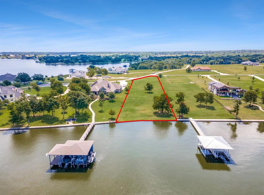 Welcome to the ideal site for your dream home on Richland Chambers Lake! Bring your custom house plans to explore this property, where you'll find expansive open water views and a gentle slope leading to the water's edge in this prestigious subdivision. Some trees provide shade across the acreage leading down to the steel retaining wall, but the majority of the land is cleared and ready for you to start building your lakeside home. In addition, there is approximately 109 feet of waterfront and deep open waters to build the perfect boat house. Sandy Cove Ranch offers luxurious amenities including a gated entry, pavilion, cabana with built-in grills, pool, hot tub, nature trails, and a private boat ramp—truly a paradise for lakefront living!