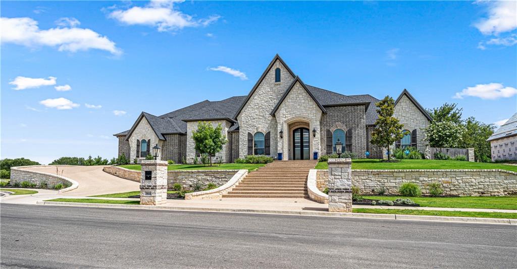 Tucked away in a private cul-de-sac within Hidden Valley, the premier community featuring some of the most desirable homes in Central Texas, this decadent, masterfully crafted home benefits from its unique location within the neighborhood, imaginative use of space, and stellar details; all of which artfully manifest in a home befitting the pages of “Architectural Digest” while still retaining an air of comfort and approachability.
From its palatial front façade to the artisan interior touches, no aspect of this home’s construction went without careful planning, an insightful envisioning of everyday use, or a curative selection ensuring that despite the home’s rich aesthetic, restrained sophistication and a true feeling of home emanate throughout.   ---   Upon reaching the peak of the home’s magnificent entry stairs, soaring double doors and masterly crafted masonry hint and what’s to come.  Once inside, handsome natural elements and an abundance of natural light perfectly transition from outside to in, beautifully highlighting the interior architectural splendor and views of the backyard pool; all with an intriguing sense of occasion.  Sprawling across two stories and 7,861 square feet, every aspect of this seven-bedroom, five-bathroom (plus a powder room!) home produces draw dropping awe.
Spacious and open, the central corridor of the home acts as the main gathering area for both entertaining and family events.  At the front, the considerable formal dining area easily accommodates seating for more than fourteen chairs and overlooks the prominent formal living room.  Cloaked in a wall of glass overseeing the spectacular pool and backyard area, this is room is always a crowd pleaser as it easily transitions to the eat-in kitchen, backyard kitchen, breakfast room, and family room; all while featuring the beautiful, soaring stone fireplace and matching archway prominently.   ---   In the home’s kitchen, an area so meticulously planned and perfectly executed, not one,