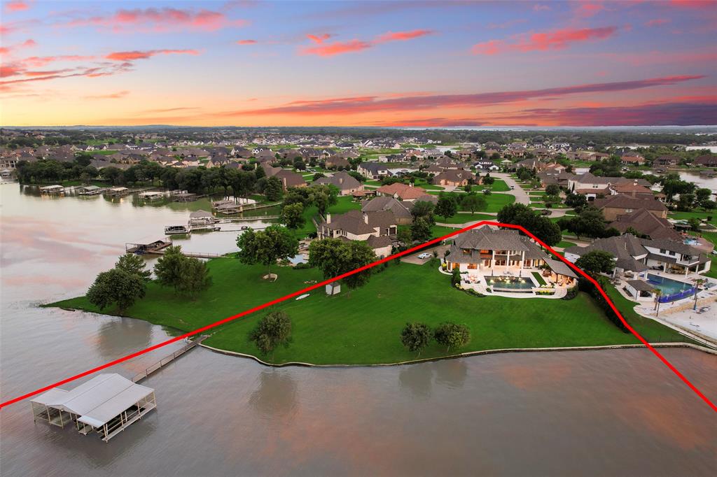 One-of-a-kind luxury lakefront estate in The Resort on Eagle Mountain Lake. Sitting on a premier lot that's arguably the most desirable on all of Eagle Mountain Lake! This custom built estate sits on 1.21 acres on a quiet cut-de-sac and is a rare & exceptional offering. The stately exterior, oversized 3 car garage behind the electric gate set the tone for what lies within, a custom 4 bedroom, 5 bath home that effortlessly combines elegance, comfort, & endless possibilities. Walking in your eyes are drawn to the huge picture windows that cover the back wall offering amazing views from every angle of the home. Soaring ceilings with custom beams throughout the main living area welcome you to the open living, kitchen, & dining area. The master suite offers breathtaking views of the lake with access to the patio, en-suite bath & large walk in closet. You will enjoy working in this oversized home office with endless views of the lake & plenty of room to turn in to two offices if needed. Additional bedroom and full bath located on the first floor as well. Upstairs features two additional bedrooms, one being a second primary with en-suite bath, and the other featuring French doors leading you to the oversized balcony with once again, breathtaking views. There's an additional room upstairs that could be used as a flex space or additional storage. Step into a truly unmatched backyard offering 300 feet of unobstructed shoreline with deep water dock access that will ensure easy launching for your boat or jet skis, year round. Not to mention a brand new infinity-edge pool and spa, custom outdoor living area with an outdoor kitchen, extended covered seating, additional storage, luxurious fire pit, and multiple seating areas making it easy to entertain. Recent upgrades include all new exterior paint, new retaining wall, landscaping, three new HVAC systems, and new roof to name a few! Designed for both entertaining and serene lakefront living, this home delivers the total package!