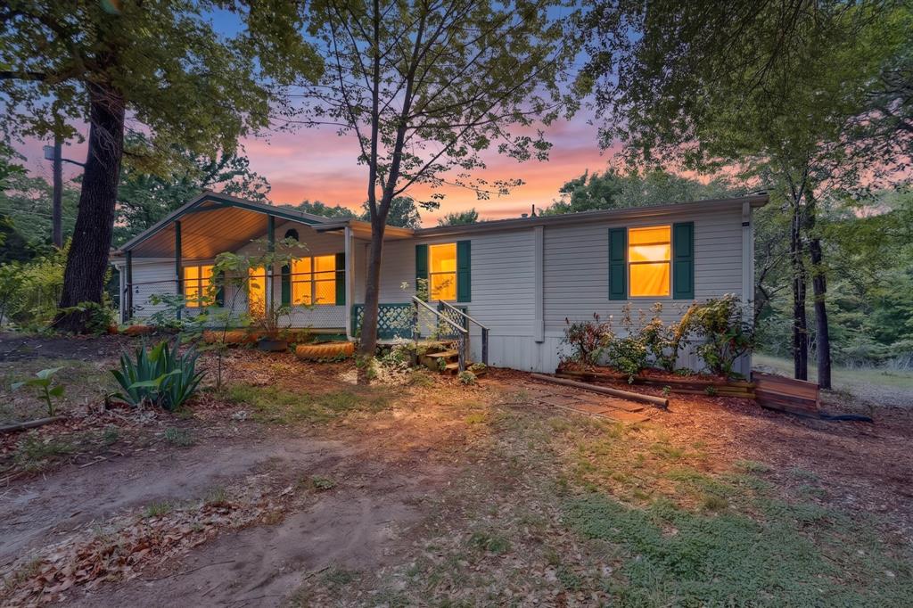Welcome to this charming property on nearly an acre in Mabank, Texas! As you arrive, you will find the home tucked in the trees, with a spacious concrete parking area and basketball hoop for a little outdoor fun. The large front porch is a cozy spot to relax and take in the peaceful, tree-filled surroundings on gently varied terrain, giving it a natural, private feel. The home features five bedrooms, offering flexibility for a large family, guests, or a home office. The open concept provides the feel of a large living room that opens to the kitchen and dining area. The primary bathroom includes a tub and two separate sink areas, while additional bathrooms are easily accessible for the rest of the home. A small laundry room adds practicality to daily living. Out back, a second porch offers another quiet place to unwind. A storage shed provides extra space, and a chain-link fence encloses the home area while leaving the rest of the acreage open.

The current owners have enjoyed this property for over 7 years and have loved living in the neighborhood for its scenery, privacy, neighbors, and its connection to the city. For instance, despite the rural feel of the home, the school bus route stops at the corner of the property and it's just minutes from well-known stores like Lowe's, Walmart, and other commercial centers. They also stated they've never experienced any flooding and have tremendously enjoyed the lake's proximity which is just a 2 minute drive!

With no HOA-POA ruling the area, the home presents a great opportunity for buyers to make it their own. With plenty of space and potential, this property is ready for its next chapter.