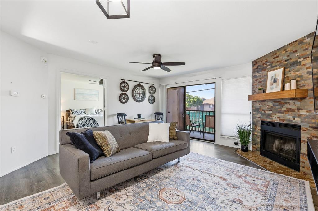 This thoughtfully updated end-unit condo on the first floor, features an open-concept floor plan with vinyl plank flooring and an inviting living area anchored by a striking fireplace. A breakfast bar connects the kitchen and living spaces, creating an ideal setup for everyday living and entertaining. The kitchen offers granite countertops, stainless steel appliances, and ample cabinet storage. French doors open to a spacious bedroom with room for a sitting area, home office, or reading nook. A generously sized walk-in closet provides abundant storage. The home also features a full size washer and dryer closet, an exterior storage closet, and a private covered balcony perfect for enjoying your morning coffee or unwinding at the end of the day. The end-unit location offers quick and easy access to covered parking and convenient outdoor access for pet owners. Residents of Cambridge Condos enjoy a gated community within Richardson ISD, featuring access to community pool, tennis court, dog park, green space, and convenient guest parking - all contributing to an active and connected lifestyle. Minutes from shopping, dining, parks, Richland College, and major commuter routes, this condo offers an appealing blend of community amenities, everyday convenience, and access to many of the area's popular destinations.