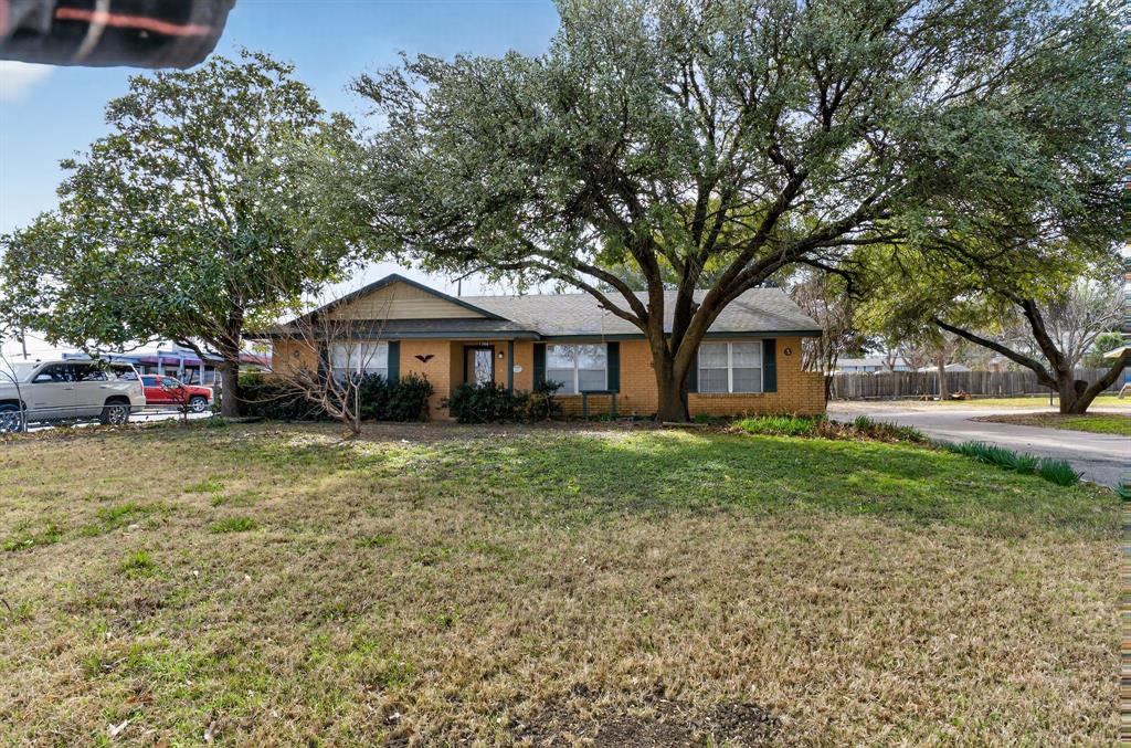 This charming 3-bedroom, 2-bathroom home features updated flooring and fresh paint throughout. As you enter through the front door, you're welcomed by a cozy, secluded living room. Adjacent to the living room is a spacious family room or dining area that flows seamlessly into the breakfast area with a built-in china cabinet. Large windows throughout these rooms provide plenty of natural light. The galley kitchen includes a cooktop, dishwasher, and built-in oven. A separate laundry room offers a sink, extra cabinets, a pull-down ironing board, and pantry space. Outside, you'll find an oversized carport with storage space and a wash sink, a fenced backyard with additional storage, and a second carport or boat cover. Conveniently located with easy access to I-35, the hospital, and nearby restaurants.