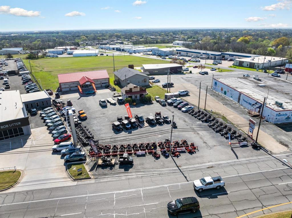 Location! Location! Location! This almost one acre spot is in a Prime location on Texoma Parkway located next to two large dealerships, Bob Utter Ford  and Texoma Hyundai. Not only is this in a prime location, but it is also in an Opportunity Zone. There is an 80x40 Climate Controlled Shop, with 2 restrooms, a 50x40 Showroom, 1 Office downstairs and 2 Offices upstairs.  There is also a Wash Bay, Work Bay, Parts Room and a Work Room; these rooms are insulated but not Climate Controlled. 
The 560 sq ft private office building was built in 2012 and has Hardy Siding, two office spaces and a coffee bar. This building could be used for private meetings or quiet office space separate from the workshop.