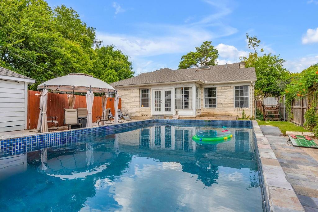 Updated Stevens Park Village POOL home. This meticulously designed private home boasts two luxurious master suites, each with full ensuite bathrooms, hardwood floors, stone counters, an inviting open-floor plan with oversized gas fireplace and sun-filled office and den combo with french doors that lead to a private outdoor oasis with in-ground pool and herb garden. Upstairs, discover a third private getaway in the open loft and third bedroom, complete with its own attached full bathroom and separately zoned air conditioning. 

Available furnished and move-in ready. Easy to show.