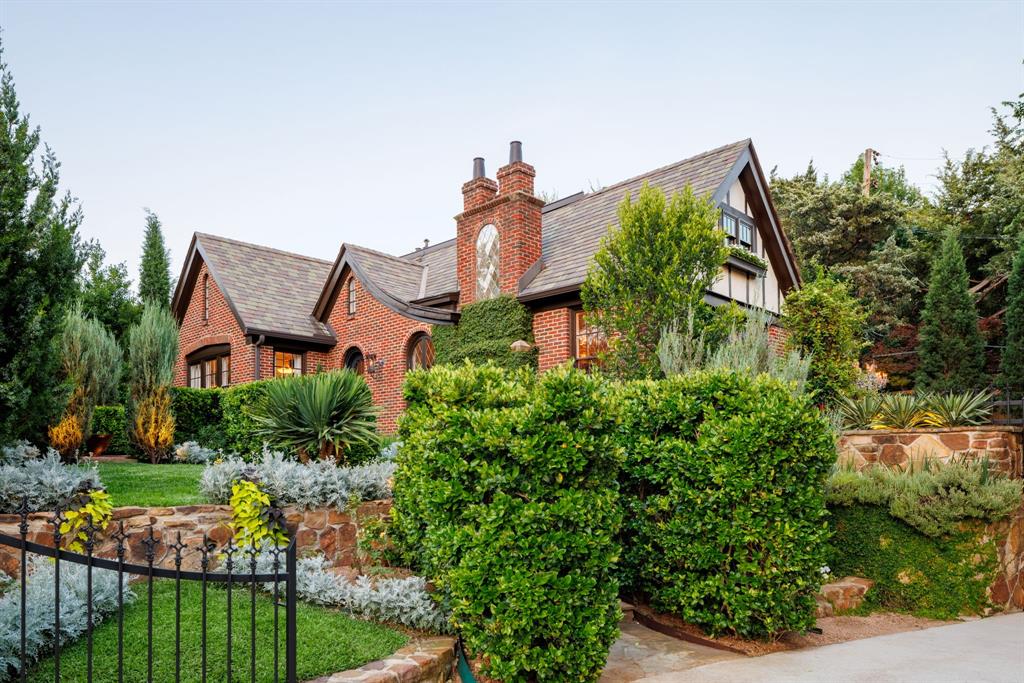 Nestled on a cul-de-sac in the highly sought-after area of Kessler Park, this 1927 Tudor has been renovated with every attention to detail including updates and quality finishes throughout. The home’s Tudor charm is restored with subtle Gothic elements and Old Hollywood design for today's living and entertaining. The neighborhood's topography, historic architecture, placement of homes on irregular shaped lots with winding streets, like this home, is unlike anything in Dallas.  
Primary suite is a resort in itself, with wall of windows which open fully to a private terrace with entertainment bar and outdoor living areas. Suite features gas fireplace, speakeasy and intimate media room. Primary suite bath features oversized shower with steam unit and Velux fresh air skylights. 
Entertaining areas outside offer a relaxing oasis with an intimate pool that has three functions: pool with chilling feature, a heated jetted spa with extra jet power built in, and when not used as a pool or spa, it is the centerpiece with multiple fountain features. Watch your favorite shows from the built-in TV while at the pool, multiple seating areas with outdoor gas fireplace. Multiple private outdoor areas to enjoy the beautiful gardens, extensive landscaping and nature. Resort-style living and a magical place to entertain and call home.