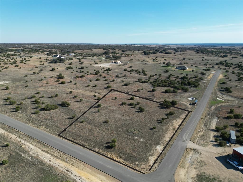 Situated on a spacious 2.5-acre corner homesite in The Ranches at Star Hollow, this property offers the perfect blend of peaceful country living and modern convenience, just 20 minutes from Granbury. The scenic community features gently rolling pastureland, scattered hardwood trees, and beautiful wide-open views. Residents enjoy paved asphalt roads, high-speed fiber optic internet, and private well water. Designed for a relaxed rural lifestyle, the community allows one large animal per two acres, chickens, and even barndominium-style homes. Build your dream home on your timeline — bring your own builder, start now or later, and even live in your RV while you build. A minimum of 1,400 square feet is required for the main residence. Enjoy quiet country living with easy access to shopping, dining, and entertainment in Granbury and Fort Worth.