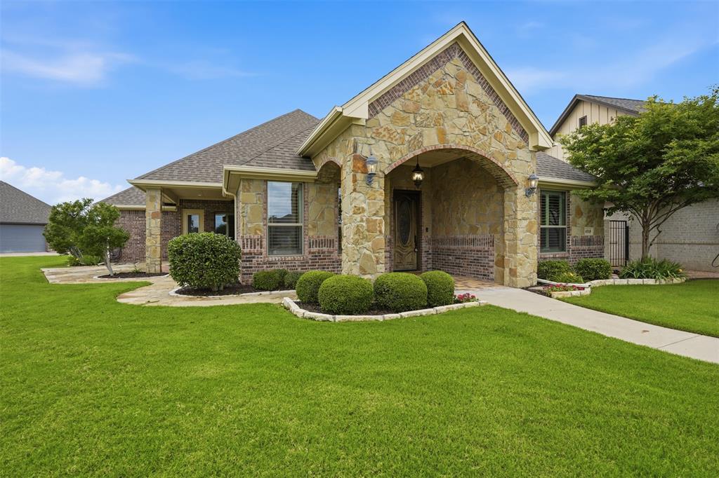 Welcome to the charming enclave of Fountain Village—a coveted gated community known for its uniquely styled custom homes, beautifully maintained grounds, and true lock-and-leave convenience. This pristine, move-in ready home offers the perfect blend of luxury, comfort, and maintenance-free living.

With a light & lovely color palette, the home showcases wide-plank engineered wood flooring in warm earth tones, plantation shutters throughout, beautiful designer surfaces, and abundant natural light creating an inviting atmosphere from the moment you enter.

The spacious open-concept is designed for effortless living & entertaining. At the heart of the home is an oversized galley kitchen that is open and connected—flowing seamlessly to the island, dining area, and expansive great room beneath a vaulted ceiling. The kitchen offers lovely granite countertops, generous bar seating, exceptional workspace, and storage galore rarely found in traditional galley-style designs. A beautiful stone fireplace anchors the living space with warmth and character.

A split-bedroom floor plan provides privacy for owners and guests. The primary suite is filled with natural light and features generous countertop space, an oversized walk-in shower, abundant closet space, and a beautifully appointed spa bath designed for comfort and functionality.

The oversized utility room offers abundant cabinetry, expansive countertop workspace, a large sink, and additional storage. Spacious courtyard and patio areas create a peaceful private retreat for relaxing or entertaining.

Ideally situated on Centre Court, this home enjoys Fountain Village amenities including fountains, gazebos, landscaped common areas, a clubhouse, and pool. Low monthly HOA dues include front yard maintenance.

Conveniently located on the Fort Worth side of Granbury, you are minutes from shopping, dining, entertainment, medical services, the Historic Granbury Square, and quick access to Fort Worth and DFW Airport.