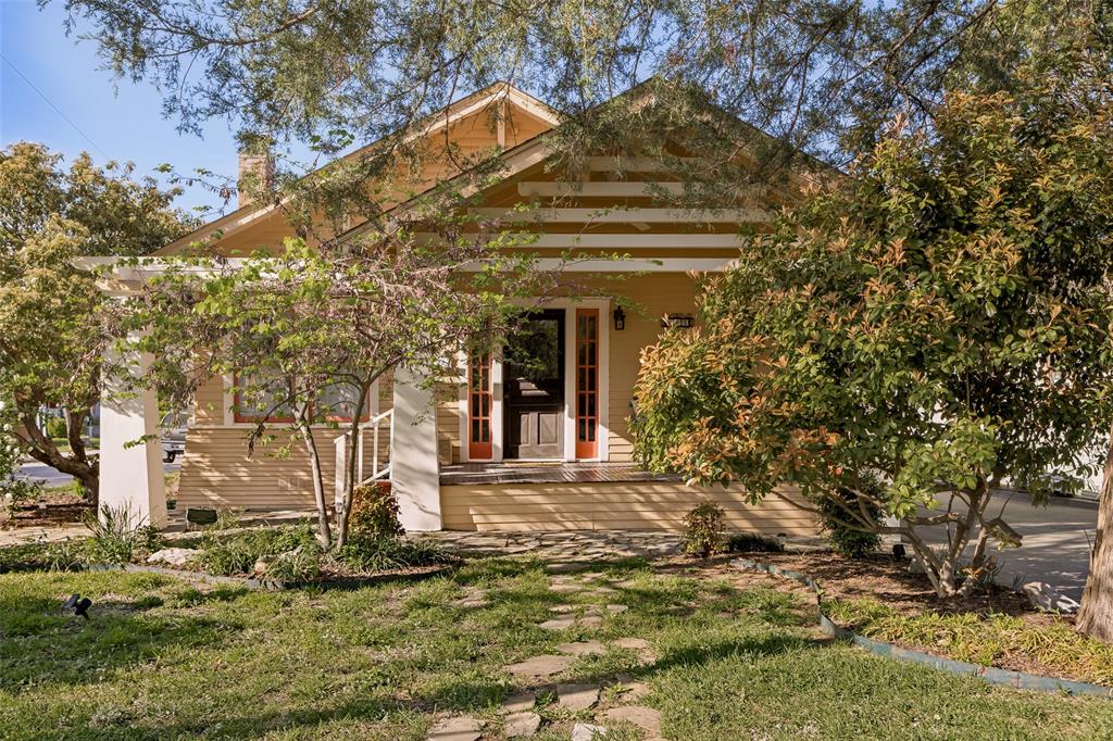 Welcome to this wonderfully charming 1930 Craftsman home in the highly sought-after McKinney Historic District. Just a scenic stroll, approximately three quarters of a mile, brings you to the vibrant downtown square, where you’ll often find a unique blend of small-town charm and character, including mounted police patrols and horse-drawn carriages that frequent the area.
Situated on a large corner lot, this property is surrounded by gorgeous mature trees, charming flagstone pathways, and inviting outdoor spaces. Whether you enjoy gardening, relaxing on one of the two porches, or simply birdwatching for a spell, this home offers a peaceful and picturesque setting.
Inside, you’ll find a true Craftsman bungalow with 9-foot ceilings and beautiful sight lines from the living room, anchored by the original fireplace, now thoughtfully converted to gas, to the lush greenery visible from the kitchen. Much of the original hardwood flooring remains, complemented by classic details such as shiplap, wainscoting, wide baseboards, and crown molding.
This is an authentic 1930s Craftsman, originally built alongside its twin on the same street and recognized on the National Historic Register for its architectural style. Original features include transom windows at the front entry, preserved interior doors, two pocket sliding doors, and glazed windows, complemented by charming plantation shutters.
Thoughtful updates include HVAC improvements, updated electrical outlets, a tankless water heater, and recent exterior painting and skirting.
The primary bedroom offers two closets, one quite spacious, with flexibility to relocate the washer and dryer and convert the current laundry room into a half or full bath.
The detached garage includes an attached storage room with potential to become guest quarters, a studio, or a creative workspace.
A rare opportunity to own a true historic gem full of character, charm, and potential in one of McKinney’s most beloved neighborhoods.