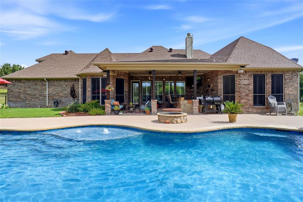 This has it ALL! Saltwater pool & spa, outdoor kitchen, 30 x 32 insulated workshop with 10 foot roll up doors, 3 car garage, 3 bedrooms plus Office plus Gameroom all on 1.318 pipe fenced acres in quiet cul-d-sac. Lush landscaping greets you into this Incredible custom home! Inviting entry features barrel ceiling, engineered hardwood floors & knotty alder front door. Office has built-ins and ceiling fan and overlooks front yard. Open floorplan has spacious living room with beamed cathedral ceiling, rock fireplace with gas starter & gas logs, built-ins, surround sound, ceiling fan & plantation shutters. Kitchen features island with granite countertop, double SS sinks, crown molding, detailed cabinetry, large pantry & more! Dining area has plantation shutters & crown molding. Large primary retreat offers 2 stage crown molding, plantation shutters & ceiling fan. Primary bath features granite countertops, double vanities, garden tub, & walk in shower with 2 shower heads. Large custom-designed closet provides double clothes rods, 2 built-in 5 drawer chests of drawers & lots of shoe & storage area. Great split bedroom floorplan. Huge upstairs Bonus Room has projector & screen, granite countertops & cabinets & area for mini fridge plus full bathroom. Outdoor oasis features large patio with commercial-grade SS outdoor kitchen with built-in flat top grill, warming drawer, sink, beverage cooler, deep fryer & storage. Granite Countertops & bar top with ample seating area. Outdoor TV stays & outdoor speakers. Playpool with attached hot tub controlled by remote for ease of use. Firepit to gather around. 30x32 foam insulated workshop with 30x20 attached covered carport for additional parking. Wired with 200 AMP service for multiple curcuits & numerous plugs. Plumbed for toilet & sink. This one is ready for new owner!  Come see Today!