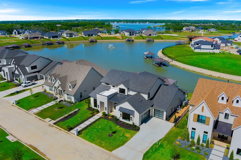 Experience lakeside living at its finest in this exquisite custom home nestled on the shores of Eagle Mountain Lake. Boasting 5 spacious bedrooms, 4.5 designer bathrooms, and a 3-car garage, this home offers an ideal blend of elegance, comfort, and functionality.

Step into an expansive open-concept great room, kitchen, and dining area, perfectly designed for entertaining. The chef-inspired kitchen features an upgraded appliance package including a 48” 6-burner gas cooktop, double wall ovens, and a built-in refrigerator. Custom cabinetry throughout the home is enhanced by soft-close drawers, floating shelves, and under-cabinet toe-kick lighting, adding both style and convenience.

The white oak wood flooring flows seamlessly through all living spaces and into the luxurious primary suite. Step outside to a massive covered patio overlooking your private pool and breathtaking lake views—an ideal space for relaxing or hosting guests.

Upstairs, enjoy a spacious game room complete with a wet bar and access to an upper-level balcony that also captures serene pool and lake vistas.

With too many high-end features to list, this home is truly a must-see. Schedule your private tour today and discover the ultimate in luxury lake living.