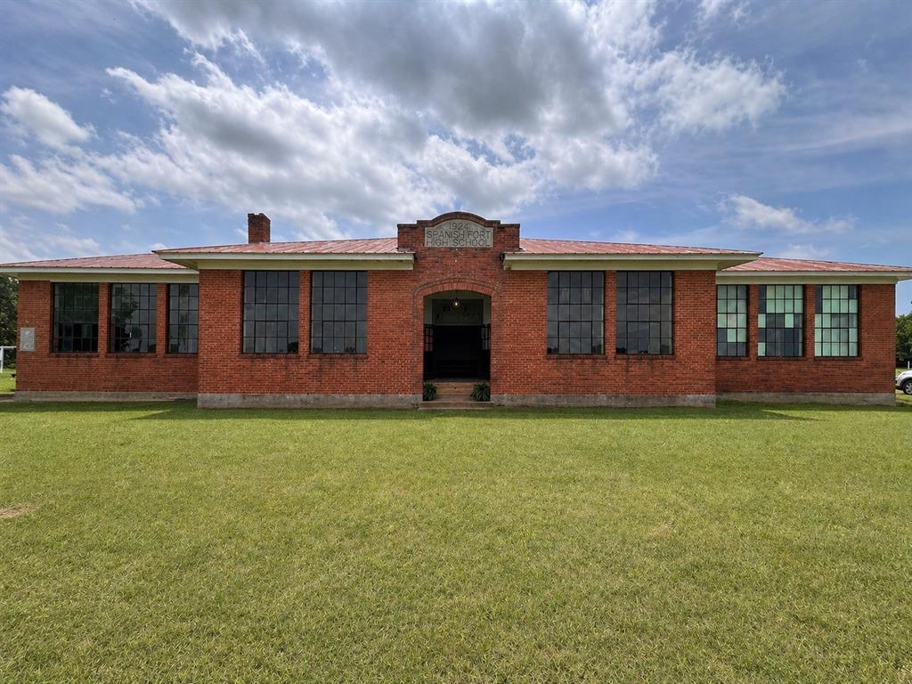 Designed by renowned Texas Architecture firm Voelcker & Dixon, the 7,000 square foot 1924 Spanish Fort High School is a testament to building practices that have stood the test of time. From its double brick walls, inch-thick plaster, vertical grain heartwood pine floors, this building is solid and ready for its next life. The fully fenced 2.6 acre property is nestled in the North Texas Hill Country and within thirty minutes of Saint Jo, Nocona, three different wineries, and Red River Station concert venue. Several events throughout the year bring in thousands of tourists from across the region. With six classrooms ranging from 400-500 square feet and a 2,400 square foot auditorium and stage, this would make a great concert venue, wedding venue, boutique hotel or an additional winery as the property lies within the Texoma American Viticulture Area and soil samples have already been analyzed by Texas A&M. Underground 200 amp electric has been added along with a new service panel.  A small room and bathroom make it possible to stay overnight. Water is currently supplied by rain water catchment and high speed internet is active at the building. There is a well and septic but both systems should be considered in need of replacement. A copy of the original blueprints is available and will convey with the sale. Listing broker is the owner of the property.