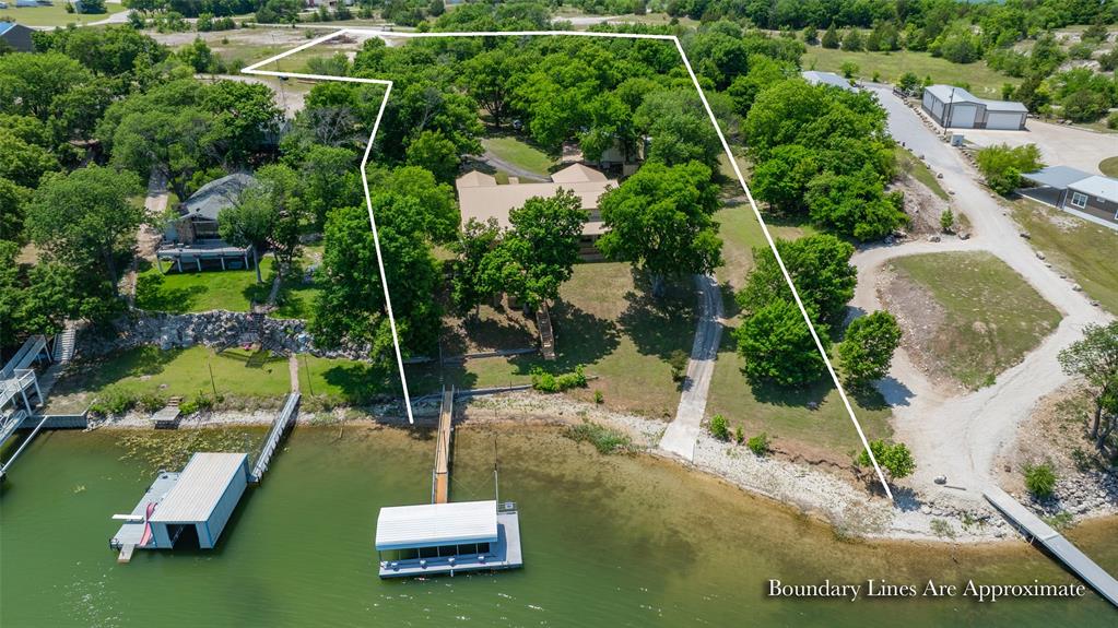 Exceptional Moss Lake retreat offering highly sought-after acreage and the perfect blend of space, privacy, and waterfront living on 4.39 acres. Enjoy breathtaking sunrises over the water, creating a peaceful and picturesque setting every day. A private driveway with gated entrance welcomes you to this secluded property. Conveniently located just minutes from WinStar World Casino and Resort, you'll enjoy easy access to dining, entertainment, golf, and resort amenities while still enjoying the privacy and tranquility of lakefront living.
This versatile lake property  offering multiple living spaces ideal for multi-generational living, guest accommodations, or income potential. The main residence features a 4,664 sq ft metal-structured and includes 3 bedrooms and 3 full baths on the primary level. Upstairs, the home offers a private 1 bedroom apartment complete with full kitchen, living area and full bath, with its own separate entrance, also accessible via an interior staircase—Then Additionally, the upper level includes a separate bedroom and an expansive 630 sq foot flex space, perfect for a bunk room, media room or game room.   This property also includes a detached 750 sq ft cabin, offering additional private guest accommodations or rental opportunity. This property has been freshly updated with new paint and a brand-new roof, providing a move-in-ready experience. A 2-car garage adds convenience and additional storage.
Outdoor and functional amenities are unmatched, featuring a 4-bay insulated shop, separate implement shop, and private well.  Enjoy direct access to Moss Lake with your own private boat ramp and dock, making this a true waterfront lifestyle property.