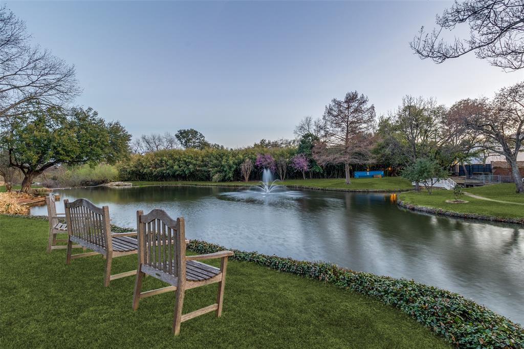 Rare lakeside retreat in the private 15-home enclave of Timberlake Gardens, just south of LBJ and adjacent to North Preston Hollow. This 5,537-sq-ft residence offers serene lake and fountain views from nearly every rear-facing window, creating a peaceful setting rarely found in North Dallas. The spacious 3-bedroom, 3-bath home features soaring ceilings, hardwood floors, a marble fireplace, built-ins, and dramatic windows that fill the living spaces with natural light. The kitchen is equipped with granite countertops, Sub-Zero refrigeration, Thermador appliances, and opens seamlessly to the den and dining areas. The oversized primary suite offers a sitting area, balcony overlooking the lake, and a beautifully remodeled spa bath. Additional features include an elevator, theater room, dry sauna, office with built-ins and beverage fridge, and wine storage for approximately 1,100 bottles. Enjoy private walking paths and direct gated access to Preston Forest shopping and dining, just steps from Cooper Aerobics Center—an ideal opportunity for luxury downsizing in a premier North Dallas location.