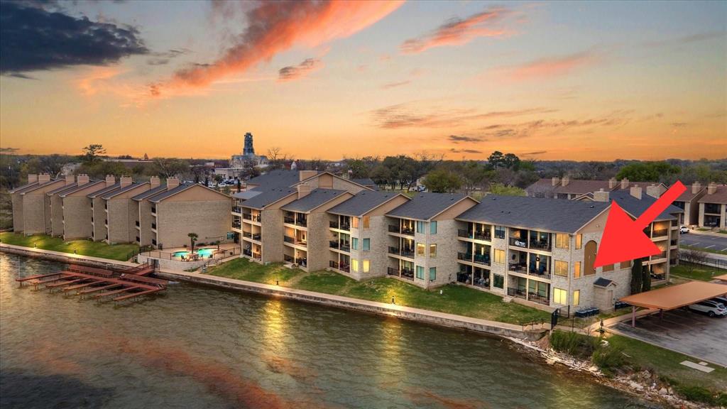 Experience the perfect blend of lakefront luxury, low-maintenance living, and walkable small-town charm in this beautifully updated 2-bedroom, 2-bath corner condominium at The Lodge on Lake Granbury. Offering approximately 1,280 square feet, this exceptional waterfront residence features panoramic lake views through expansive windows, allowing you to enjoy stunning sunsets and even Granbury’s spectacular fireworks displays from the comfort of your living room.

Designed for both comfort and convenience, this condo features granite countertops, an induction cooktop, and all new appliances in 2022. Recent updates include all new windows, remote-controlled insulated shades on the lakeside, plantation shutters in the front, along with bamboo flooring in the office.

Step outside to your extra-large private patio and enjoy all the benefits of lakefront living without the maintenance. Residents enjoy amenities including a private dock, swimming pool, fitness center, clubhouse, covered parking, and the convenience of additional parking and storage units available for rent on-site. HOA dues include cable, internet, water, sewer, and trash.

Located just 0.1 mile from the historic Granbury Square, you’ll enjoy walking to award-winning restaurants, wineries, boutique shopping, entertainment, and year-round festivals. Adjacent to Granbury City Beach, Hewlett Park, and scenic walking trails, this home offers the best of Granbury’s vibrant, patriotic community. With no short-term rentals allowed, residents enjoy a more private and community-focused environment. Conveniently located approximately 45 minutes from Fort Worth and 75 minutes from Dallas.