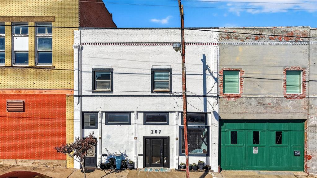Mixed-use property located at 205 & 207 E Houston Street in Historic Downtown Sherman, just one block from Sherman Square. This unique building offers a combination of residential loft living above street-level retail space, creating an ideal opportunity for an owner-occupant or investor.

The second-floor loft features exposed brick walls, an open-concept living and kitchen area, two bedrooms, and two full bathrooms. Additional highlights include a large private back patio and a versatile all-season room suitable for a home office, studio, or additional flex space.

The ground floor consists of street-level commercial retail space with strong visibility and pedestrian traffic in one of Downtown Sherman’s active corridors. Surrounded by restaurants, shops, and entertainment venues, the location offers convenient access to the Square and nearby downtown redevelopment projects.

This property presents a flexible opportunity for live-work use or income-producing investment with potential retail, office, studio, or boutique tenant space below and residential living above.