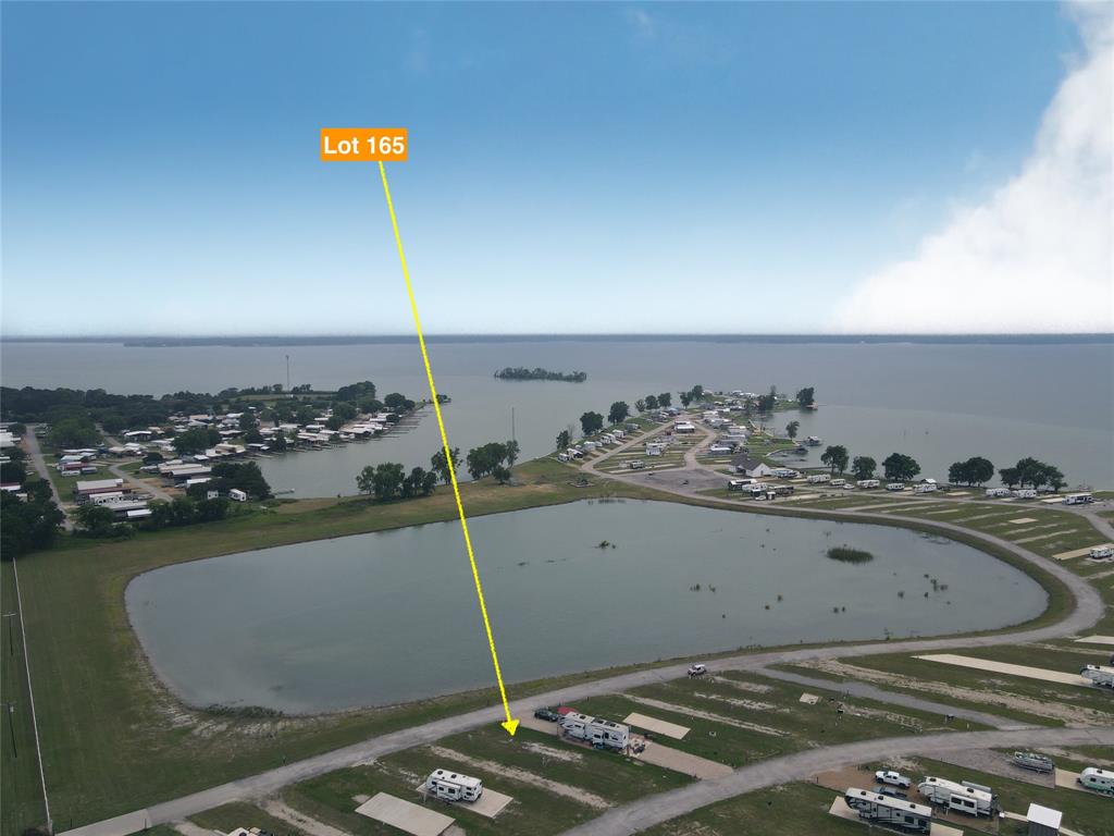 If you’ve been dreaming of a peaceful escape by the water, Lot 165 in Peninsula Point might just be the perfect place to bring that vision to life. Tucked away in a friendly and charming RV community on the shores of Richland Chambers Lake, this lot offers everything you need to start enjoying the laid-back lake lifestyle right away. The gravel driveway is already in place, so whether you’re bringing in your RV or planning to park your tiny home, access is easy—and you’ll love the relaxing view overlooking the community pond. One of the best perks? The water tap fee has already been paid, which means the lot is ready to use without the added hassle or extra cost. As a resident of Peninsula Point, you’ll have access to a great lineup of community amenities, including a gated entrance for peace of mind, a welcoming clubhouse, and a sparkling pool that’s perfect for cooling off on those warm Texas days. There’s even a boat ramp so you can easily get out on the water whenever the mood strikes, plus a playground to keep the kids entertained and an on-site laundry facility for added convenience. In addition, short-term rentals are allowed in the community, so whether you’re looking to create your own weekend retreat or generate some extra income when you’re not using it, you’ve got flexible options. Lot 165 is more than just a piece of land—it’s a chance to create your own little slice of lakeside paradise. Whether you're looking for a serene personal escape, a fun family hangout, or a smart investment opportunity, this property is ready to deliver. Come see what life by the lake could look like—you might just fall in love.