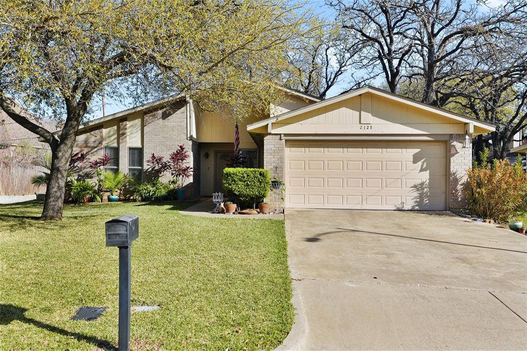 Welcome to 2127 Holt Rd in North Arlington where location, comfort, and lifestyle come together. Ideally situated just minutes from Texas Live!, Globe Life Field, AT&T Stadium, Six Flags, Hurricane Harbor, and conveniently close to DFW Airport, this home places you at the center of it all while still offering a sense of privacy and retreat. This home offers 3 bedrooms and 2 bathrooms, along with fresh interior paint that enhances its clean and updated feel.
Inside, you’ll find vaulted living area with exposed beams and expansive windows providing natural light throughout. Open-concept design connects seamlessly to the dining space, ideal for both everyday living and entertaining. Wood laminate flooring adds warmth and continuity, while the wood-burning fireplace with mantle anchors the room.  Just off the main living space, a unique space which provides a charming and versatile area for a studio, work out room, to unwind, recharge, or start your day. Kitchen with granite countertops, tile backsplash, white cabinetry, stainless steel appliances, and a vented range hood. Recessed lighting and efficient layout provide functional workspace and storage. A dedicated dining area adds to the home’s functionality for both everyday living and entertaining with access to a spacious backyard with mature trees, tiered patio, and covered patio area for shaded outdoor seating. Landscaped beds and multiple hardscape zones support entertaining or simply relax in your own private space.
With its unbeatable location and inviting layout, this home presents an exceptional opportunity to enjoy all that Arlington has to offer.
