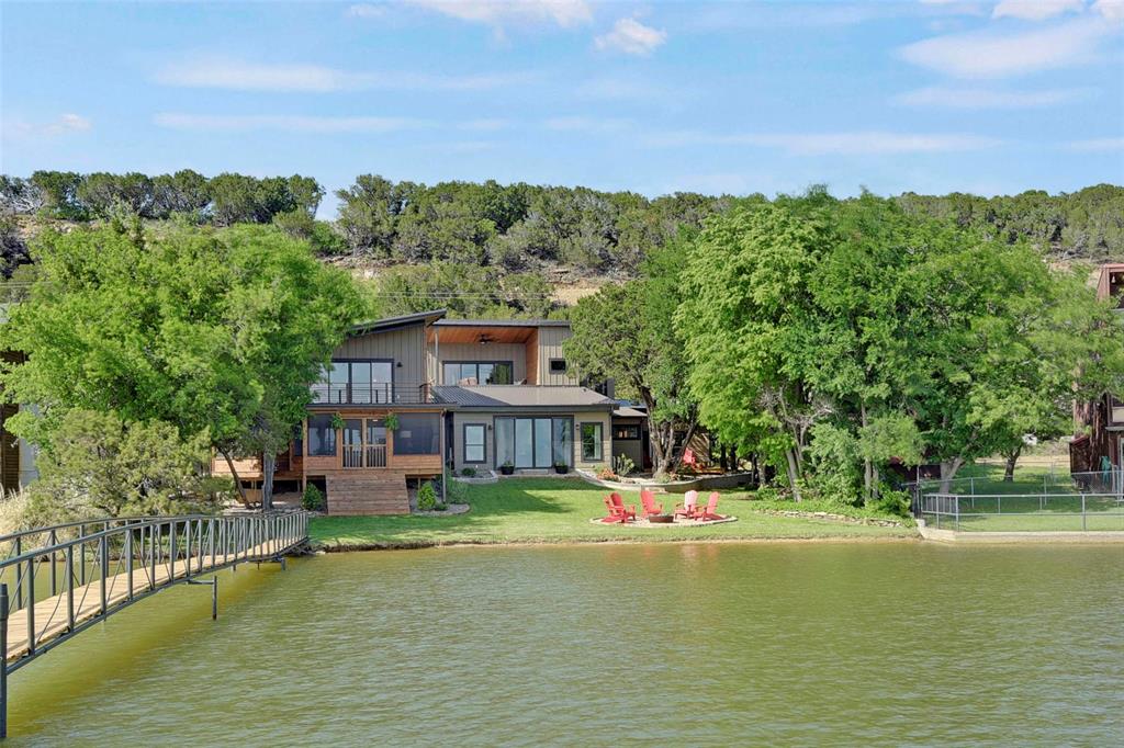 Huge price reduction at no fault of the property. Modern Chic and Classic Comfort set the mood for this impressive lakefront home with many designer touches. The Sunlit corridor leads to a comfortably appointed living space with vaulted shiplap ceilings, lovely chandelier,  gracious leather seating and an expansive glass slider offering blue water views. The eat in designer kitchen boasts gorgeous cabinetry and gourmet appliances including a sub zero like fridge. Well equipped  coffee or wine bar with built in cooler allows for ease of access from either the living or kitchen spaces. You will find Two lower guest suites off of the left wing of the home, each well appointed, one hosts a murphy bed, beautiful built in cabinets and access to a large private outdoor patio. The Upper master suite with balcony offers tranquil lake side views, large closet and ensuite bath. The right wing of the property is host to a huge den with built in bar, handsomely outfitted and perfect for lounging or shooting a game of pool. The upstairs apartment offers an ensuite bath and a full kitchenette for your guests with a large lakeside balcony sure to keep them coming back. But there is more, Enjoy the expansive lakeside screened porch for gaming, dining  or just chilling after a day on the lake offering plenty of seating. Gentle walk to covered dock with upper deck for sunbathing, 1 slip with lift and PWC lift. Turnkey and ready to enjoy! Welcome home!