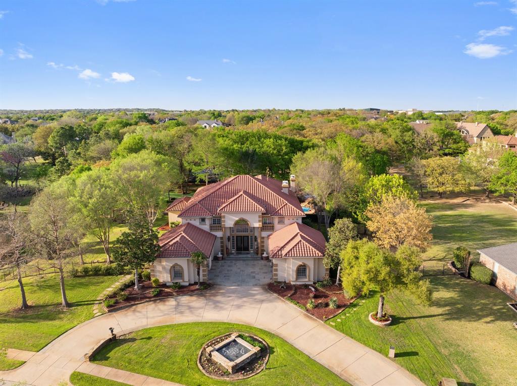 Experience resort-style family living in this custom Toll Brothers estate on a private, heavily treed 1-acre lot in Southlake Woods. This 5,821 square foot home features 5 bedrooms, 4.5 baths, soaring ceilings, expansive windows, and open-concept living spaces filled with natural light. The gourmet kitchen, complete with high-end stainless steel appliances and oversized island, flows seamlessly into family and entertaining areas. The serene owner’s retreat offers a fireplace, private balcony, sitting area, and spa-inspired bath with soaking tub, walk-in shower, and dual vanities. Families will appreciate four guest bedrooms, a game room, media room, and flexible space for homework, play, or hobbies. Outdoor amenities include a Claffey-designed pool with slide, firepit, full outdoor kitchen, Nicklaus Design putting green, Rhino sport court, and lush landscaping maintained by a private water well and Mosquito Nix system, making it perfect for children and entertaining. Unique interior touches include a 1,000-bottle wine room, cigar humidor, and smart home automation. Located near top-rated Carroll ISD schools, shopping, dining, and DFW Airport, this turnkey estate offers the ideal combination of luxury, convenience, and a lock-and-leave lifestyle for families seeking space, safety, and style in Southlake’s most prestigious neighborhood.