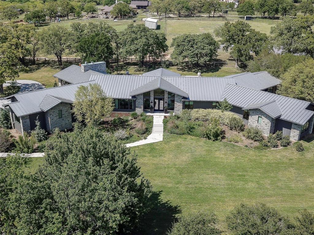 Private, custom, contemporary estate - leave stress behind as your gate opens to beautifully landscaped gardens & trees surrounded by Ag Exempt pastures.Bartonville is a hidden gem w~ exotic animals nestled among equestrian ranches & still just a few minutes from city amenities.Peaceful mornings begin watching animals graze while sitting on extensive multi-tiered patio’s surrounding a sparkling pool perfect for entertaining large groups. Home was designed w~indoor-outdoor living in mind w~spectacular views from every room w~ walls of windows & sliding doors. Luxury abounds w~ Miele kitchen appliance suite, built in espresso machine, luxurious owner’s suite w~ glass & marble shower, heated floors, spa Jacuzzi tub, & huge closet w~ large safe. Even the electronic bidet has a heated seat! Home also has a storm shelter off the owner’s suite & separate Barndominium w~2 bedrooms, family room, full kitchen & space for all your toys w~loft storage, & attached garage for RV, mowers & more!