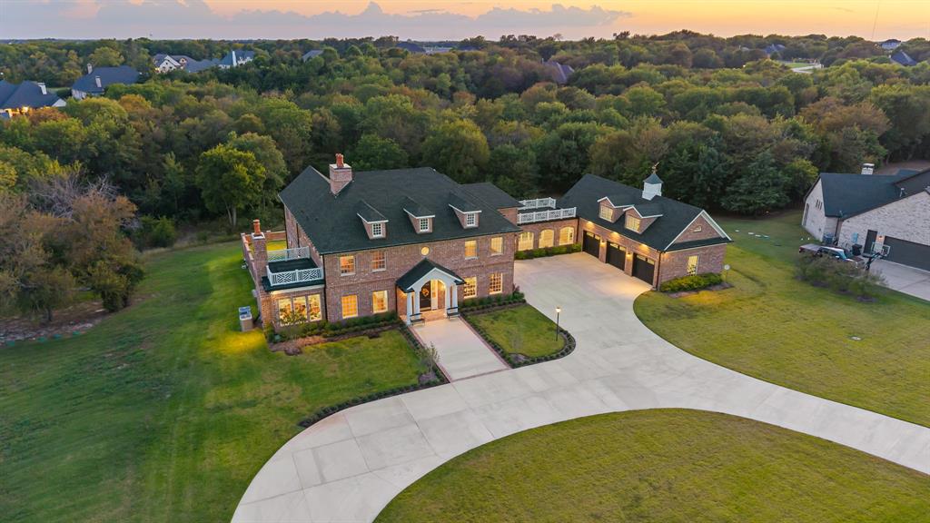 Step into timeless elegance with this one-of-a-kind Georgian Colonial estate, masterfully designed with craftsmanship and sophistication at every turn. Nestled on a serene, tree-lined 2-acre lot, this custom home welcomes you with a grand circle drive and stunning curb appeal, setting the tone for the refined luxury within.  Inside, you’ll find rich custom woodwork, exposed brick accents, and an abundance of natural light that fills every room. The chef’s kitchen is a culinary dream, featuring a massive prep island, top-tier appliances, and a walk-in appliance pantry designed for both beauty and functionality. Enjoy morning coffee in the sun-drenched solarium, or unwind with a good book in the private home library. The expansive executive office offers an inspiring setting for the most discerning professional—ideal for hosting meetings or managing business affairs in style.
An in-home elevator provides effortless access to every level, including spacious attic storage. Step outside to experience multiple patios and balconies overlooking the peaceful, wooded estate—perfect for entertaining or quiet reflection. A brick-laid breezeway connects to the oversized three-car garage, completing this remarkable property that seamlessly combines grandeur and comfort. This home is truly a rare find—a timeless statement of design, privacy, and luxury living in the heart of McKinney. Versa lift in garage; attic above garage is unfinished bonus room 48x13; elevator to second floor and attic on third floor; brick floors; Documents listing the many features can be found in Transaction Desk; double lot allows for addition of a pool house with guest quarters but not a second residence.