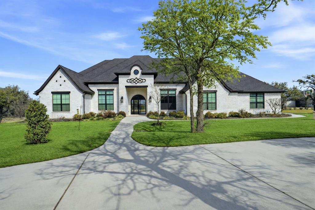 Couto Custom Home in Aledo is a stunning French Traditional Estate exuding timeless elegance & modern comfort. A grand U-shaped driveway sets the stage for this impressive executive home, offering a warm welcome to guests. Step inside to discover exquisite craftsmanship throughout, from extensive millwork & rich wood flooring to designer lighting, high-end fixtures, & architectural details that define sophistication. Set on 2 lush acres surrounded by mature trees & impeccable landscaping, this property offers privacy, serenity, & an inviting atmosphere. The chef’s kitchen is a true showpiece, featuring double islands, built-in appliances, a butler’s pantry, & walk in pantry, seamlessly connecting to the spacious dining area, ideal for hosting gatherings. The primary suite is a luxurious retreat with a stunning multiple tray ceiling, spa-like ensuite bath with dual vanities, a large walk-in shower with dual shower heads, & an expansive custom closet. Each of the four bedrooms offers generous space & comfort. Enjoy the dedicated study with French doors, a large game room with wet bar, & a state-of-the-art media room featuring a cove ceiling with LED lighting, surround sound, projector, screen, & tiered theater seating. The family room showcases a dramatic floor-to-ceiling stone fireplace & coffered ceiling, with double sliding doors opening to a private backyard oasis, the perfect space for entertaining or unwinding. Additional highlights include a whole-home generator; Michael Phelps swim spa; & an attic lift providing easy access to a fully insulated storage space above the garage. This extraordinary home is more than a residence — it’s a personal retreat where luxury, comfort, & thoughtful design come together. Relax in your private spa setting or entertain with confidence, knowing every detail has been crafted to impress ONLY 9.5 MILES TO LOCKHEED MARTIN. HIGHLY SOUGHT AFTER ALEDO ISD.NOTE The Michael Phelps Swim Spa is included but can be removed at buyer request
