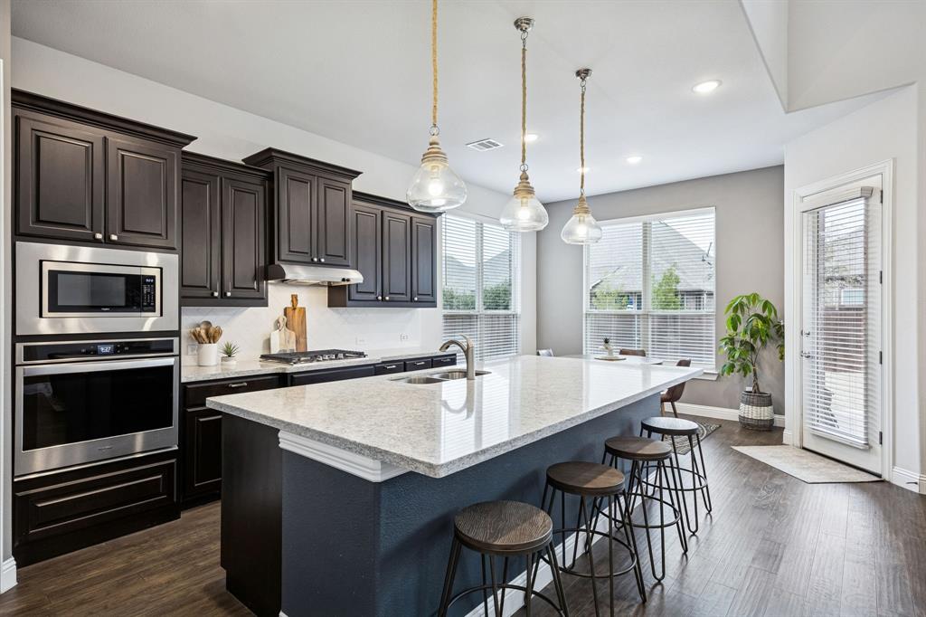 Welcome to this stunning 4-bedroom, 3.5-bath home in the highly sought-after Trinity Falls master-planned community in McKinney. Situated on an oversized one-third-acre, pool-sized lot, this beautifully maintained home offers an open-concept floor plan, soaring ceilings, abundant natural light, and a rare 3-car garage. A charming covered front porch and private entry lead into a welcoming foyer with rich hardwood floors throughout the main living areas. Just off the entry, a dedicated home office with French doors provides the perfect space for remote work or study, while the formal dining room is ideal for gatherings and entertaining. The impressive living room features dramatic 24-foot ceilings, expansive windows, a cozy gas fireplace, and seamless flow into the gourmet kitchen. Designed for both entertaining and everyday living, the kitchen boasts granite countertops, an oversized island, abundant cabinetry, built-in oven and microwave, stylish lighting, and a walk-in pantry. The first-floor primary suite serves as a private retreat with soaring ceilings and an extended layout. The spa-inspired bath features dual vanities, a garden tub, separate shower, and oversized walk-in closet with custom storage. Upstairs, you'll find a spacious game room, three secondary bedrooms with walk-in closets, and two full bathrooms. One bedroom includes a private ensuite bath, making it ideal for guests, multigenerational living, or a private teen suite. Step outside to enjoy the extended covered patio and expansive backyard, offering endless possibilities for outdoor entertaining, gardening, play, or future pool construction. Residents of Trinity Falls enjoy resort-style amenities including multiple pools, parks, playgrounds, scenic ponds, walking and biking trails, a clubhouse, community events, and an on-site elementary school. Conveniently located near shopping, dining, major highways, and everything McKinney has to offer.