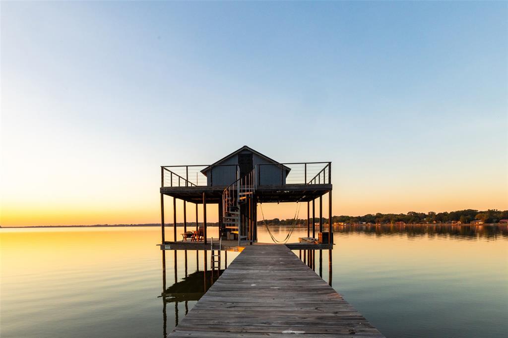 Don’t miss your chance to own your own piece of relaxation and enjoyment at Cedar Creek Landing. This half acre waterfront lot features a cozy one-bedroom boathouse equipped with running hot and cold water, electricity, a microwave, and a mini fridge—ideal for a quick weekend getaway. The property also features a newly painted deck, adding a refreshed and inviting outdoor space.  The private dock includes a boat lift for convenient storage and effortless lake access. This is the perfect opportunity to build your dream home within this exclusive gated community and enjoy direct access to Cedar Creek Reservoir for boating, fishing, or sunset entertaining. Cedar Creek Landing offers resort-style amenities, including a clubhouse with fitness center, an infinity-edge swimming pool, a boat launch, and an open-air lounge overlooking the lake—all just minutes from Cedar Creek Country Club. Experience lakeside living at its finest—whether you’re seeking a full-time residence or a relaxing retreat, this property beautifully combines luxury and leisure.