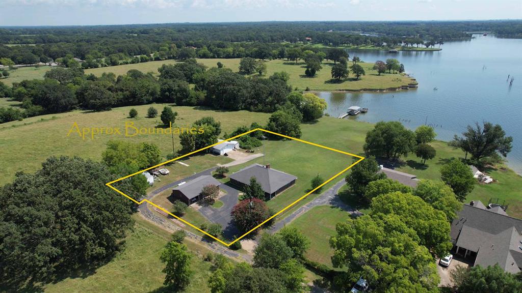 Incredible waterfront opportunity on the world-famous Lake Fork—priced To sell!! This unique property includes a spacious 1,915 SF primary home with 2 bedrooms, 2 baths, and a detached 2-car garage—plus a charming 625 SF guest house with 1 bedroom, 1 bath, full kitchen, and an attached 1-car garage. That’s a total of 2,565 SF of living space—perfect for multigenerational living, guests, or rental income potential. The main home features an oversized living room bathed in natural light from a wall of windows, offering beautiful views of White Oak Bay on the world-renowned Lake Fork. Enjoy cozy evenings by the gas fireplace or entertain with ease in the open-concept layout. The kitchen is a dream for home chefs, complete with updated appliances, abundant counter space, a large breakfast bar, and warm ash cabinetry—all designed to keep you connected to guests while you cook. Step outside to enjoy your private oasis: a fenced yard, circular drive, RV pad site, and your very own boathouse. Wake up to stunning sunrises over the lake from the back deck, or sip coffee as the peaceful waters set the tone for your day. The guest house is more than just an extra space—it’s a fully functional retreat with a full kitchen and bath, ideal for visitors, long-term stays, or even a personal studio or man cave. With panoramic views, practical amenities, and unmatched flexibility, this waterfront gem on world-famous Lake Fork offers a rare chance to own prime lakefront living. Don’t miss out—schedule your tour today!