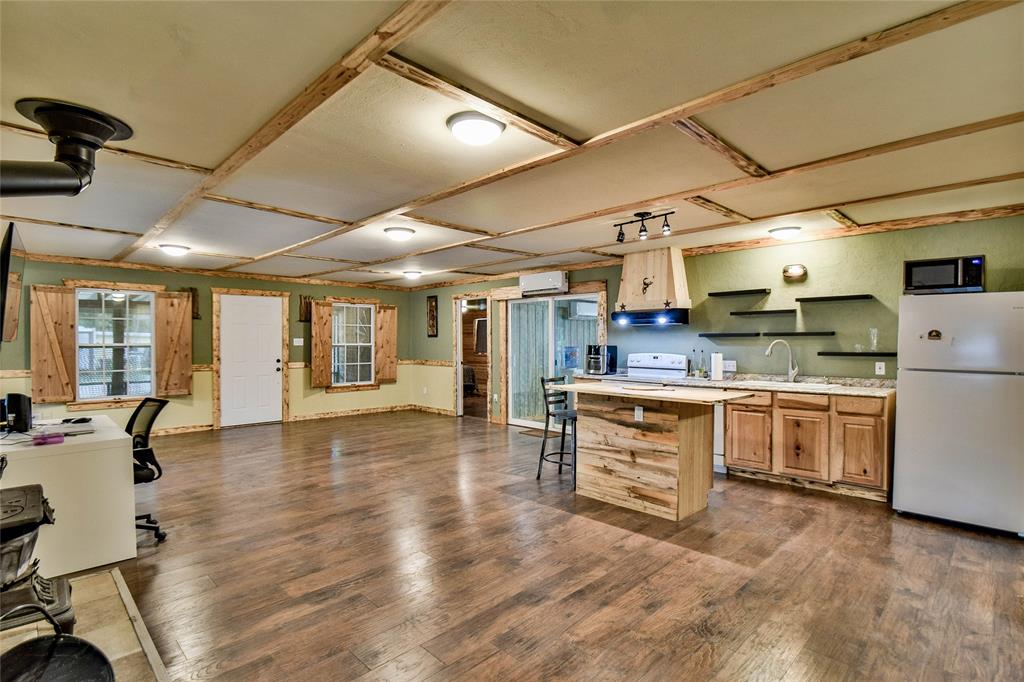 Don't miss out on this great 3 bedroom 2 bath home just blocks away from Lake Granbury. This modern rustic hand crafted home features knotty pine paneling and new laminate flooring. Over-sized open concept living area with plenty of room for office, exercise room, arts and crafts area with plenty of storage. The roomy kitchen features a wood island and plenty of built-in cabinets with beautiful wood countertops. Impressive, hand-painted pantry room door opens to a huge walk-in pantry. Spacious primary bedroom with ensuite bathroom featuring double bowl vanities on cutom-made vanity stand. Separate custom shower with beautiful tile and a warming towel bar - wrap yourself in a warm towel! Relax on the hugh enclosed, screened-in  decks - both front and back porch. Fantastic second living area complete with it's own kitchen and laundry room, gas stove, stainless steel sink, plus a bonus room for whatever space you need! ALL updated PEX flexible plumbing installed. Community offers swimming pool and boat ramp only a few blocks away! Property includes two lots - 5711 and 5713 Flint Dr.  Don't delay - call for a showing today!