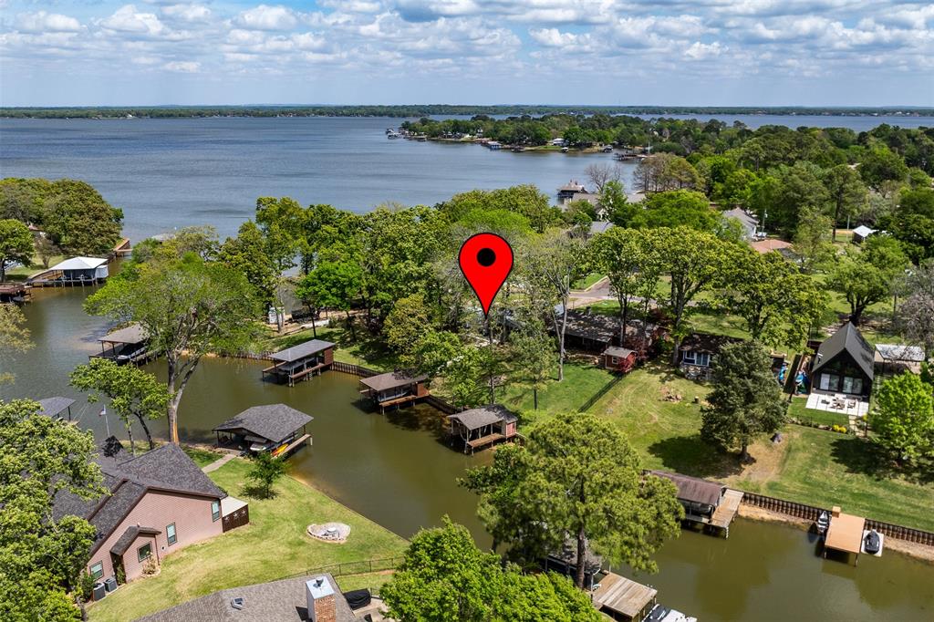Deep water channel, this home is a must see! Fully furnished lake house with everything you need to enjoy lake living!  Open kitchen and living, wood burning fireplace, vaulted ceilings with wood beams create beauty and space. Outside is a nice, covered deck, a cement patio, cement sidewalk down to the water. The boathouse has electric lift and recently added cradle, new ladder to get in and out of the water. The wide boathouse deck is great for fishing, swimming and sitting by the water.  At full lake level, the channel is about 7' deep and even when lower, boats can still get in and out. Roof was recently replaced, electrical updated including new panel, new chimney cap and flashing, recent exterior paint. Over the last few years, new windows and doors, HVAC. Established yard with French drains on both sides, landscaping and large shade trees and storage building. Sewer converted from septic to public sewer. Beautiful Cedar Creek Lake is only an hour from Dallas, Tx. and is a favorite for both fishing and recreational activities.